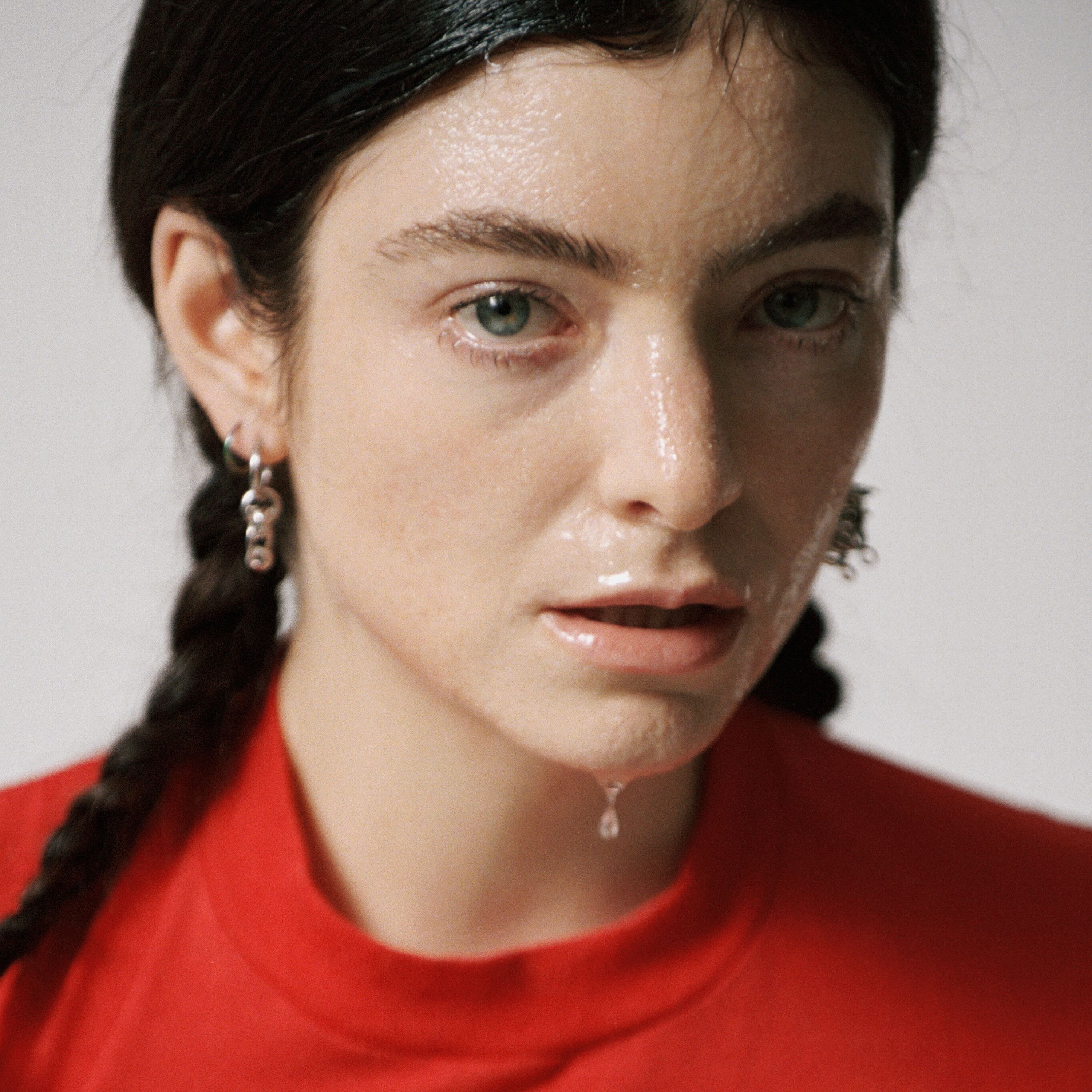 Close-up of Lorde's face dripping in sweat against a white background while wearing a red shirt. Released on Apr. 23, the first music video for the singer's fourth album marks the start of the artist's new era. (Courtesy of Universal Music New Zealand Limited)
