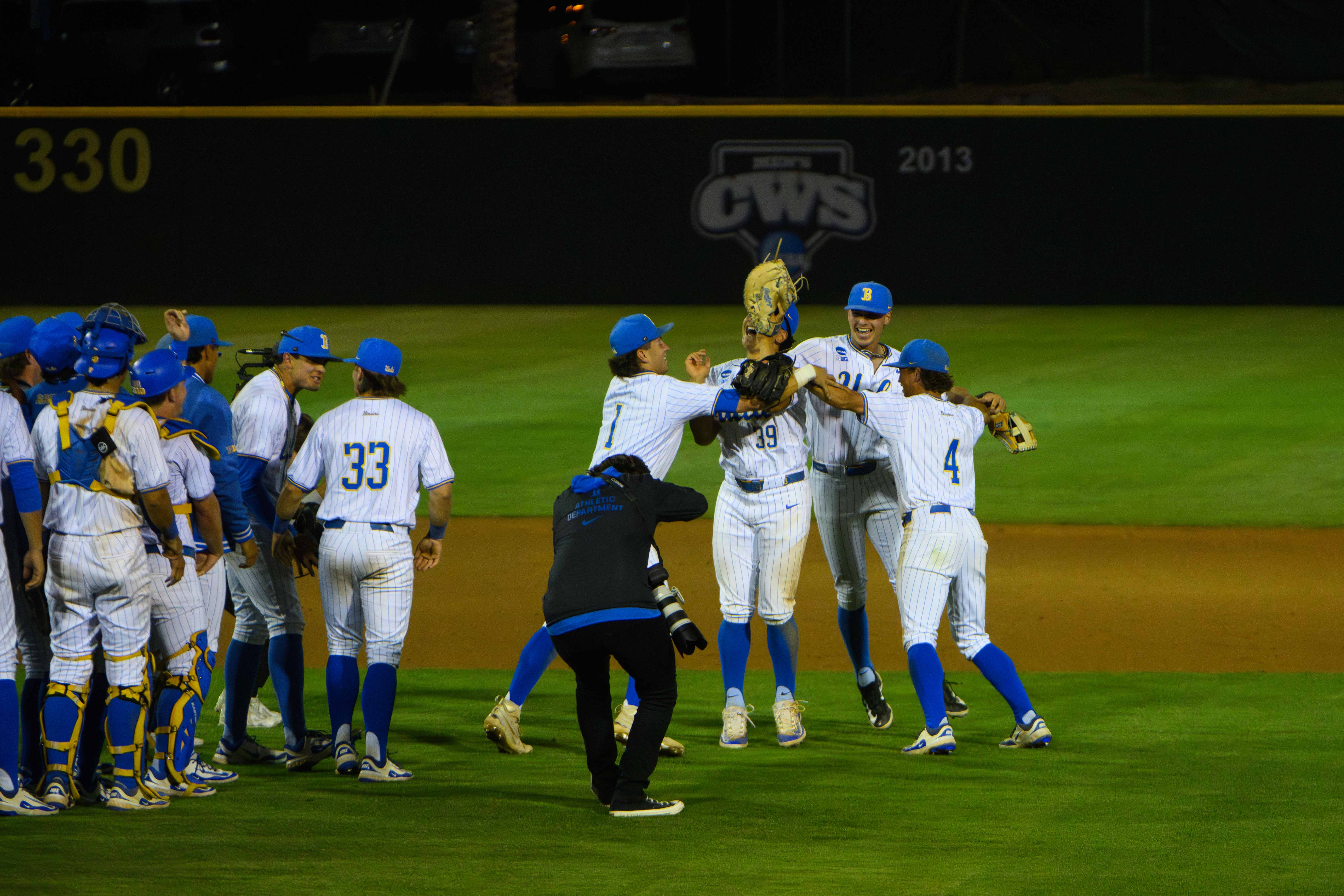 Sophomores shortstop Roch Cholowsky, first baseman Mulivai Levu, third baseman Roman Martin and second baseman Phoenix Call (left ro right) celebrate in a circle after a win with their teammates nearby. (Michael Gallagher/Assistant Photo editor)
