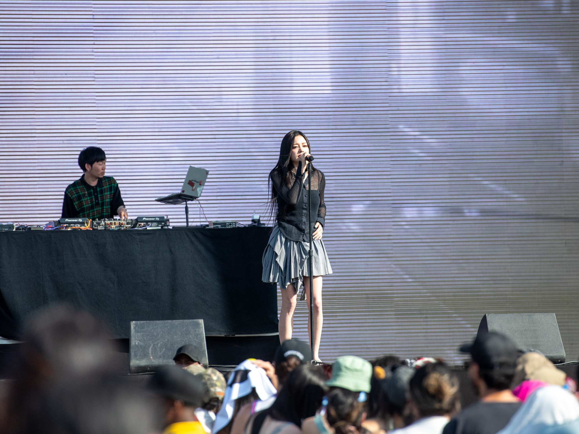 Miso performs on stage while wearing a black long-sleeved shirt and gray skirt at the first day of Head in the Clouds Music & Arts Festival. The festival&squot;s first day was held in Pasadena, California on Saturday, where Miso performed songs such as "Where Did I Go," "Alone" and "Slow Running." (Max Zhang/Daily Bruin)