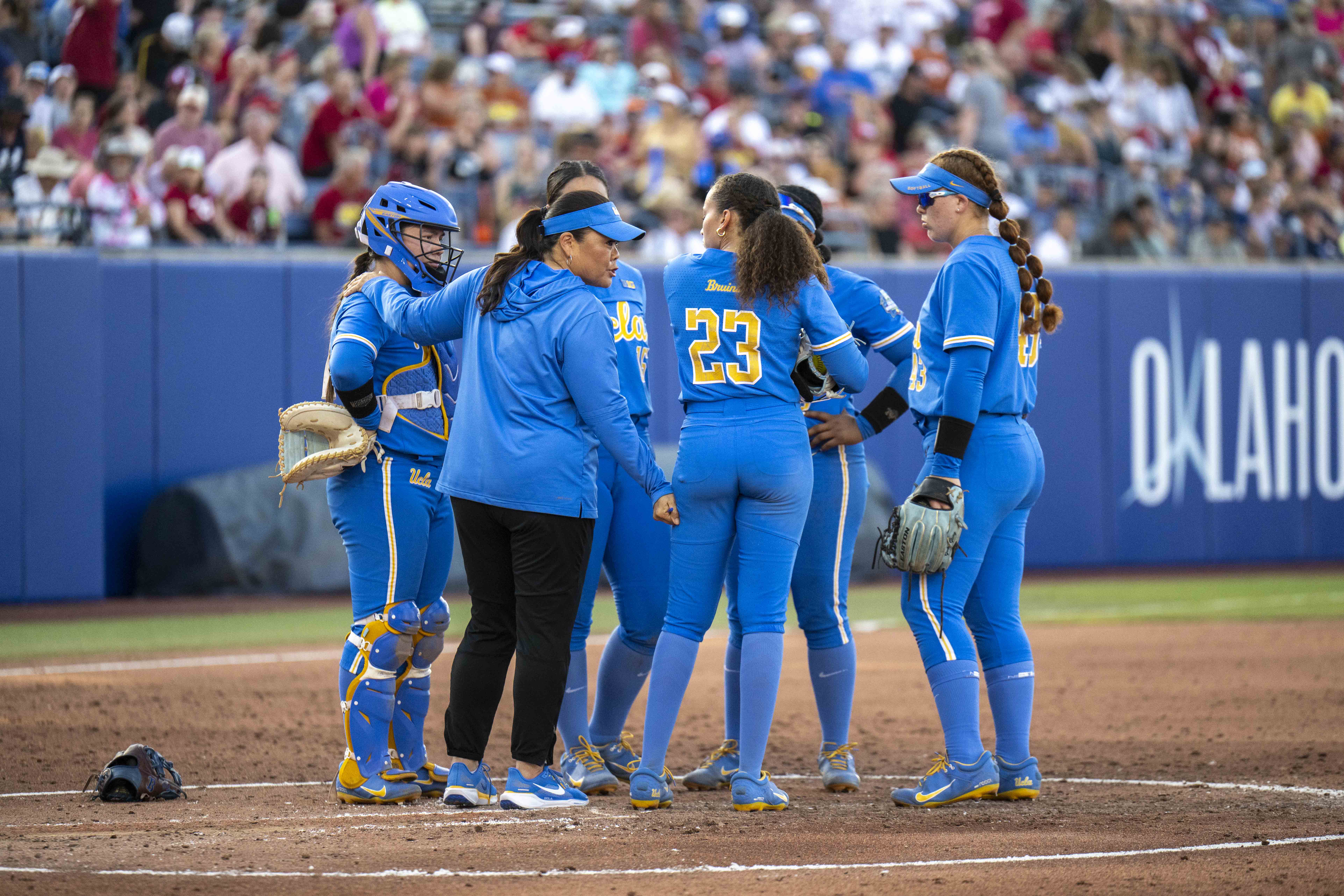 Inouye-Perez and several UCLA softball players meet in the pitcher's circle. (Karla Cardenas-Felipe/Daily Bruin staff)