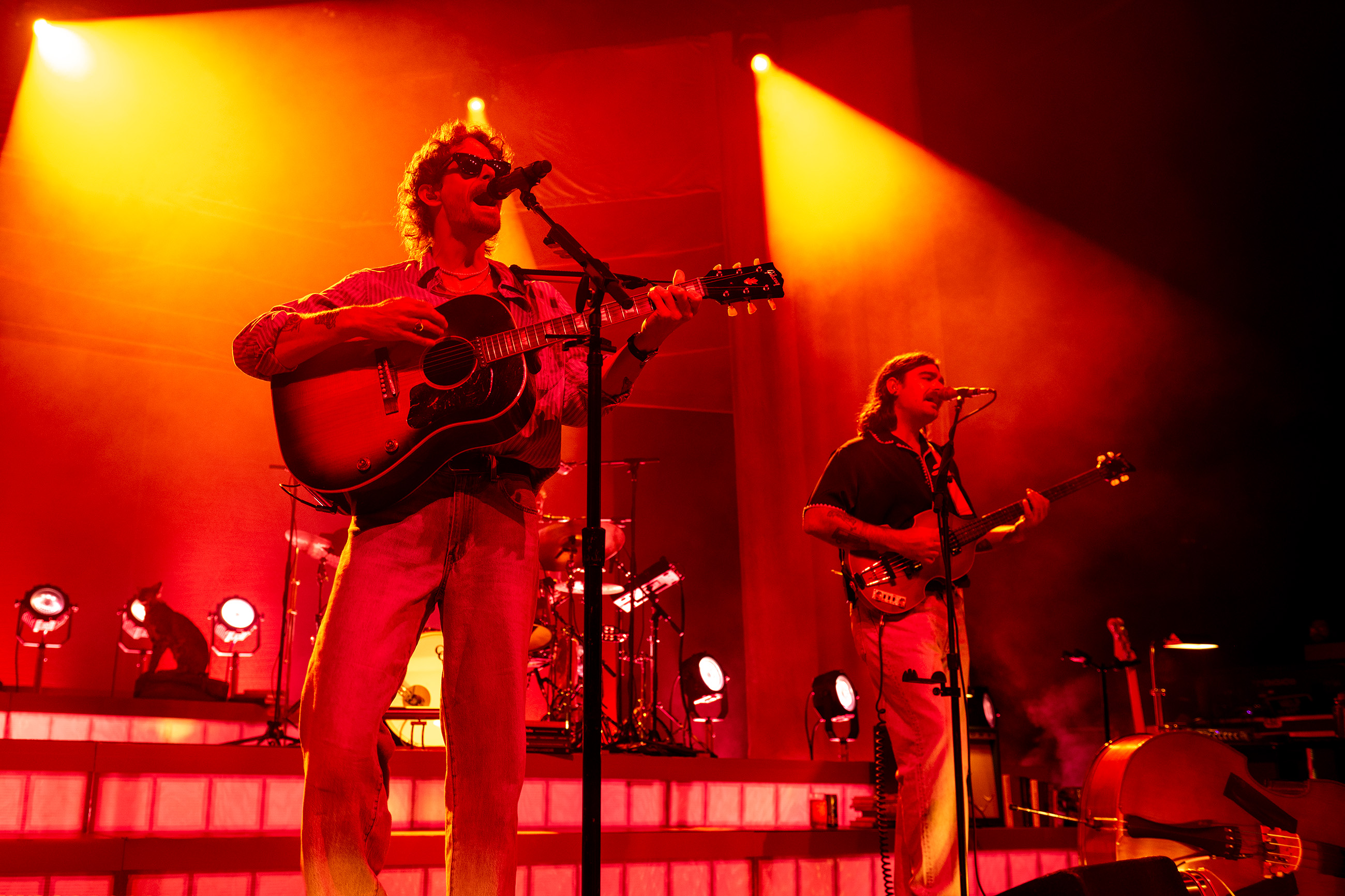 Meier and Caamp's bassman Matt Vinson stand side-by-side on stage while singing into their own microphones. The band's genre complemented the venue's atmosphere with its intimate and slow-paced sound. (Isabella Appell/Daily Bruin)