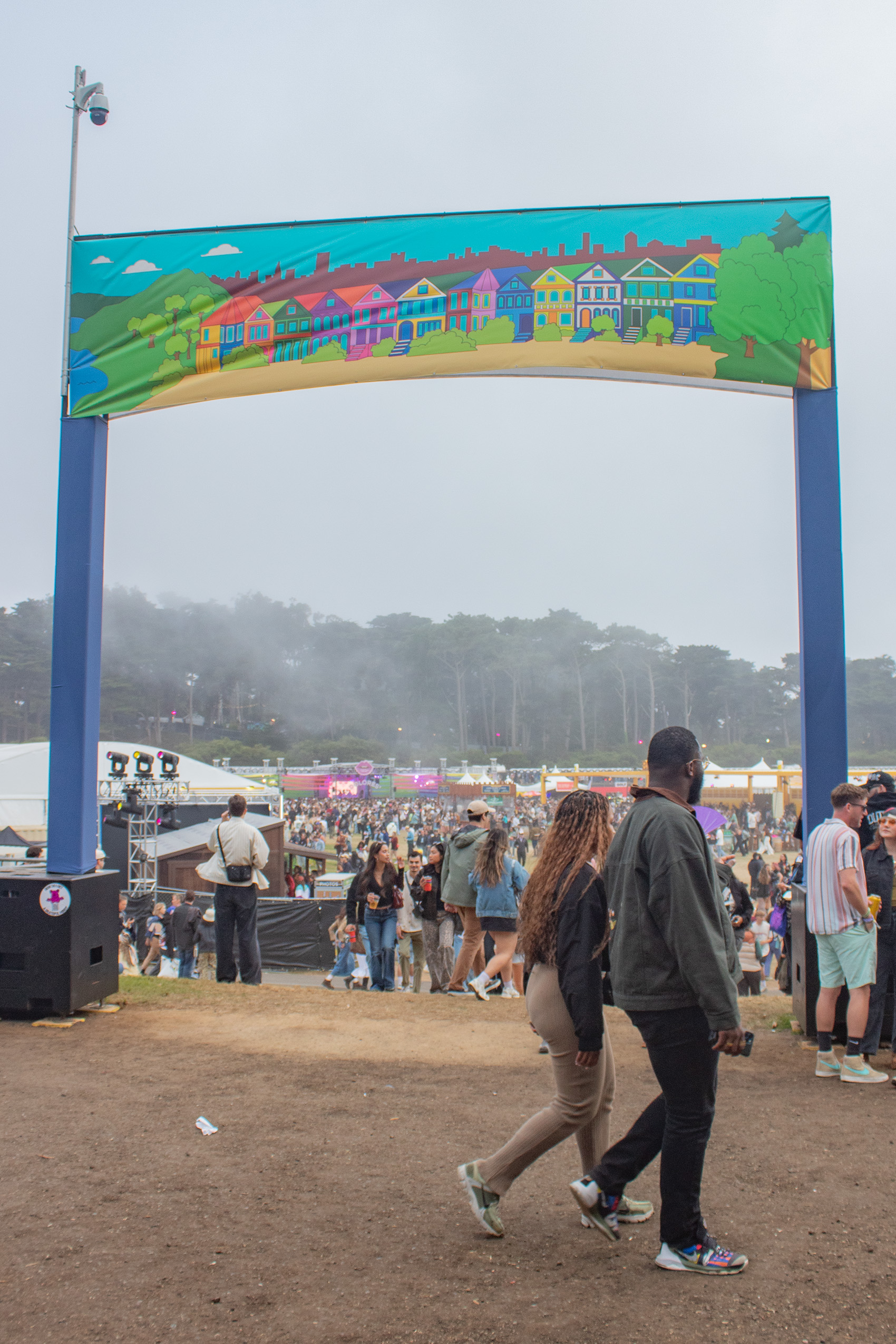 Festival attendees walking around the Outside Lands' grounds, near an arched entrance with an illustrated banner. Indie rock band flipturn played a 45-minute set early on the second day. (Isabella Appell/Daily Bruin)