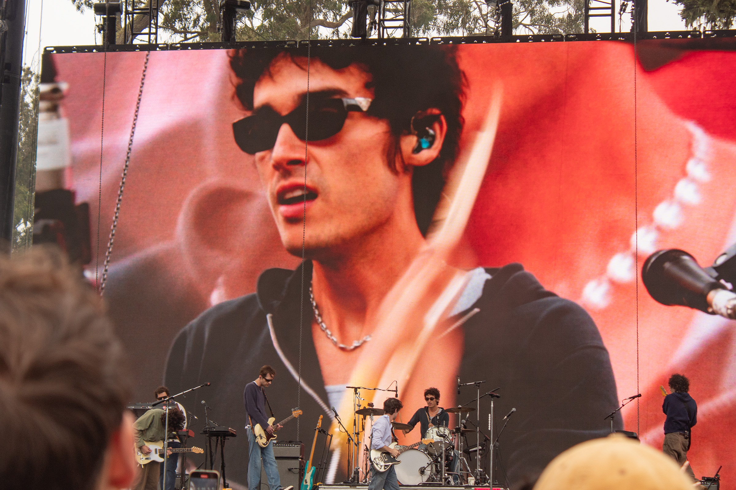 Pictured is Wallows on stage, with drummer Cole Preston on the screen. The alt-rock band's set featured both high-energy songs as well as multiple crowd interactions. (Isabella Appell/Daily Bruin)