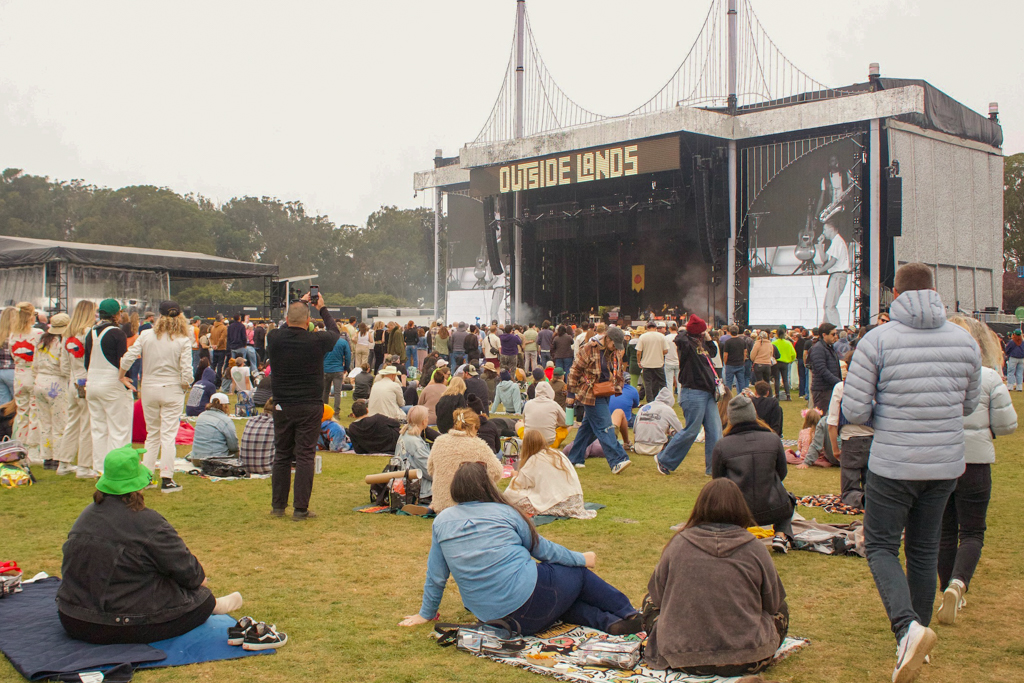 Pictured are festival attendees sitting down to watch an act at the Lands End stage. Singer and producer FINNEAS performed a 50-minute set, featuring songs from his upcoming project. (Isabella Appell/Daily Bruin)