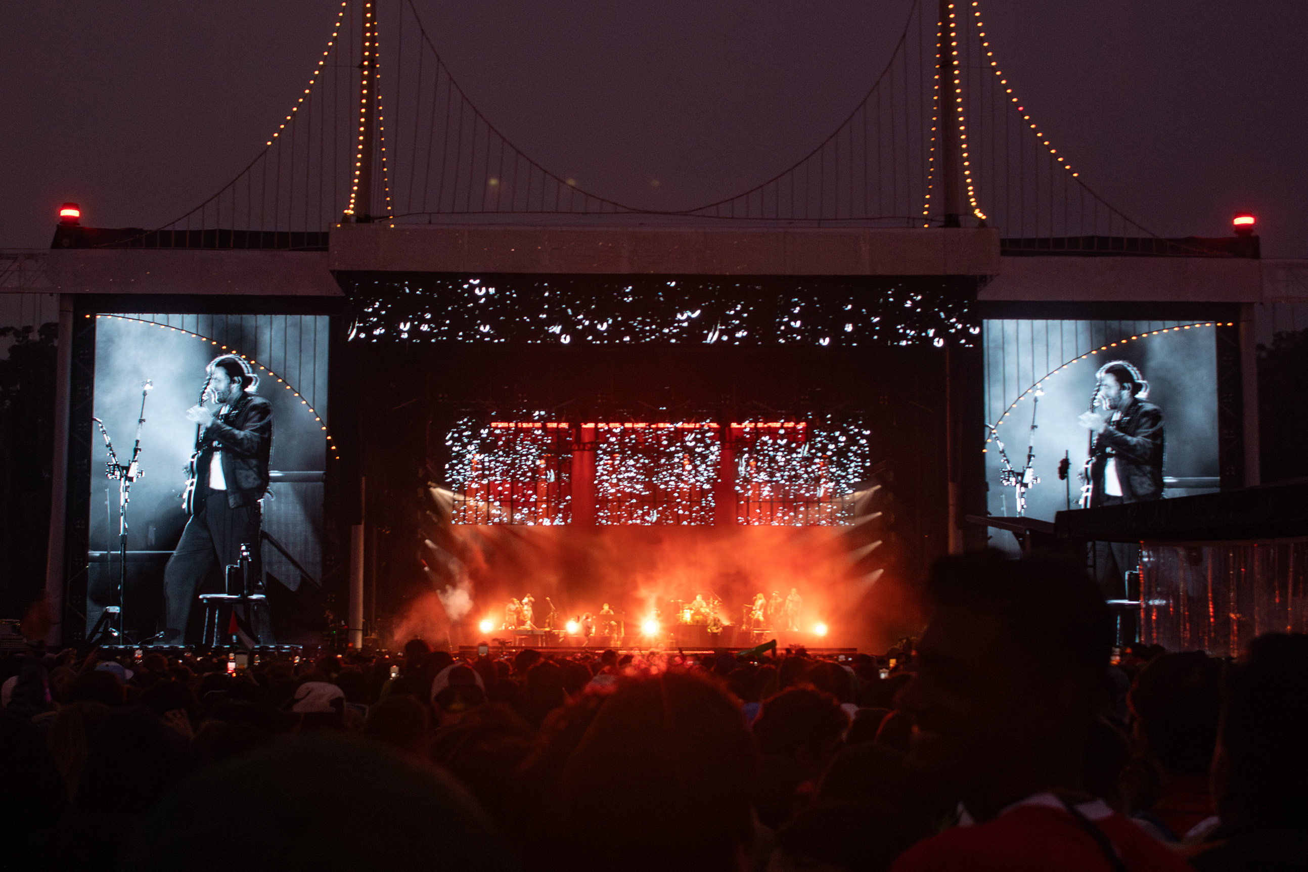 Seen is Hozier performing with his guitar surrounded by red lights. As one of the festival's closing acts, the Irish singer captivated the crowd with his powerful and vulnerable voice. (Isabella Appell/Daily Bruin)