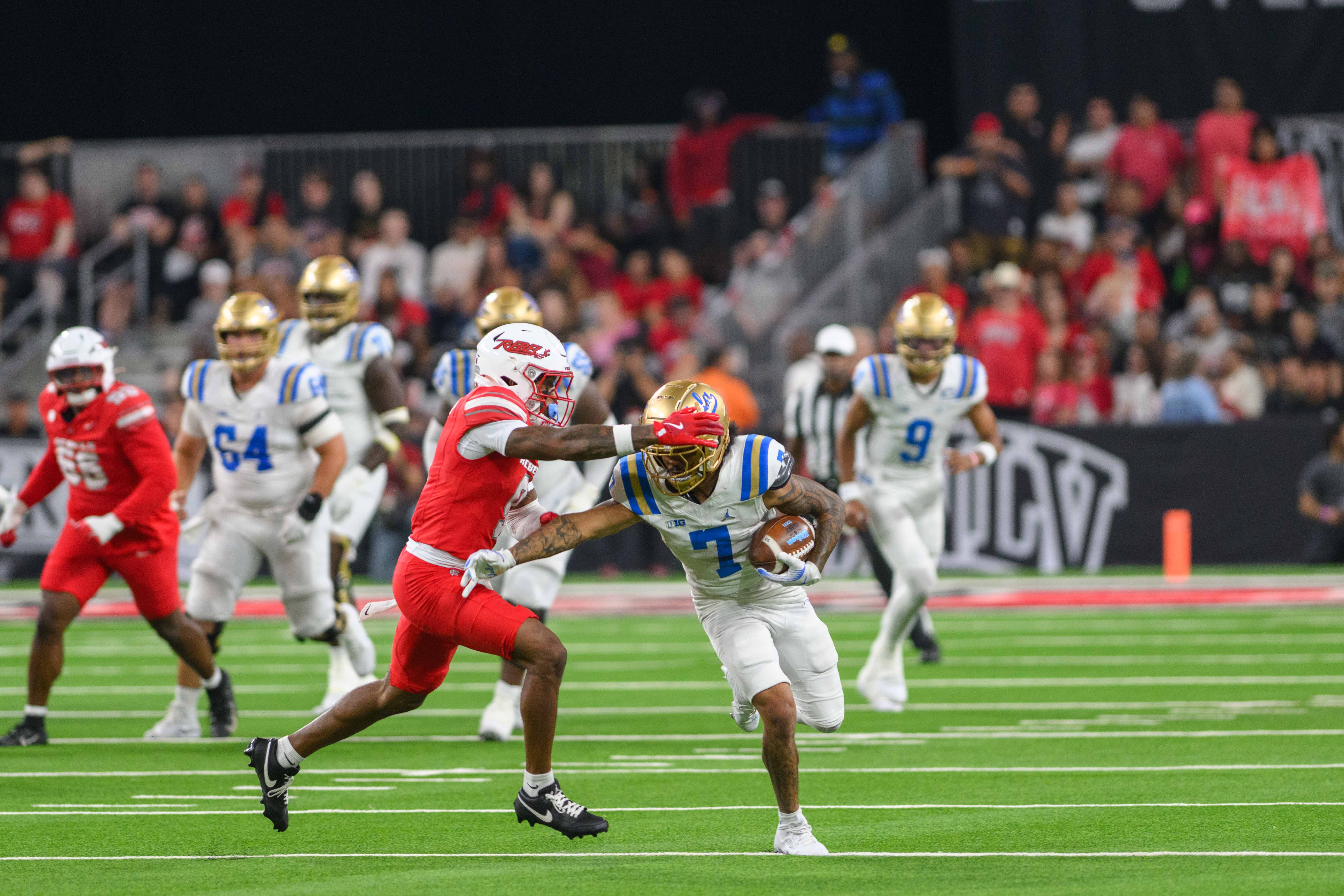 Junior wide receiver Mikey Matthews runs down field as a defender attempts to tackle him from the side.