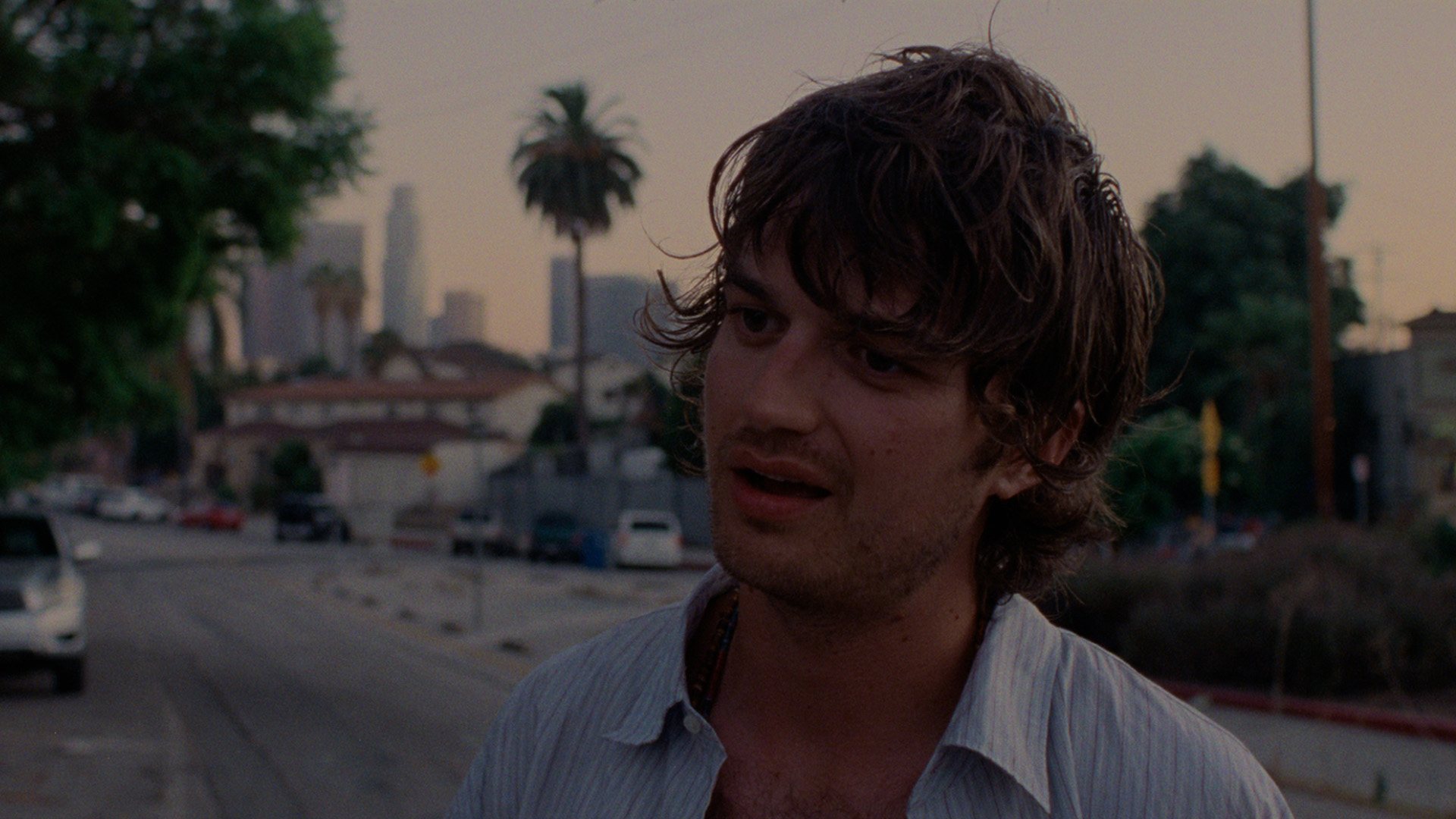 Still of Tame Impala’s “Loser” music video, featuring Joe Keery. The video released Sept. 3 and tells the story of a man moping on the curb outside a store, after being left by his lover.” (Courtesy of Columbia Records)