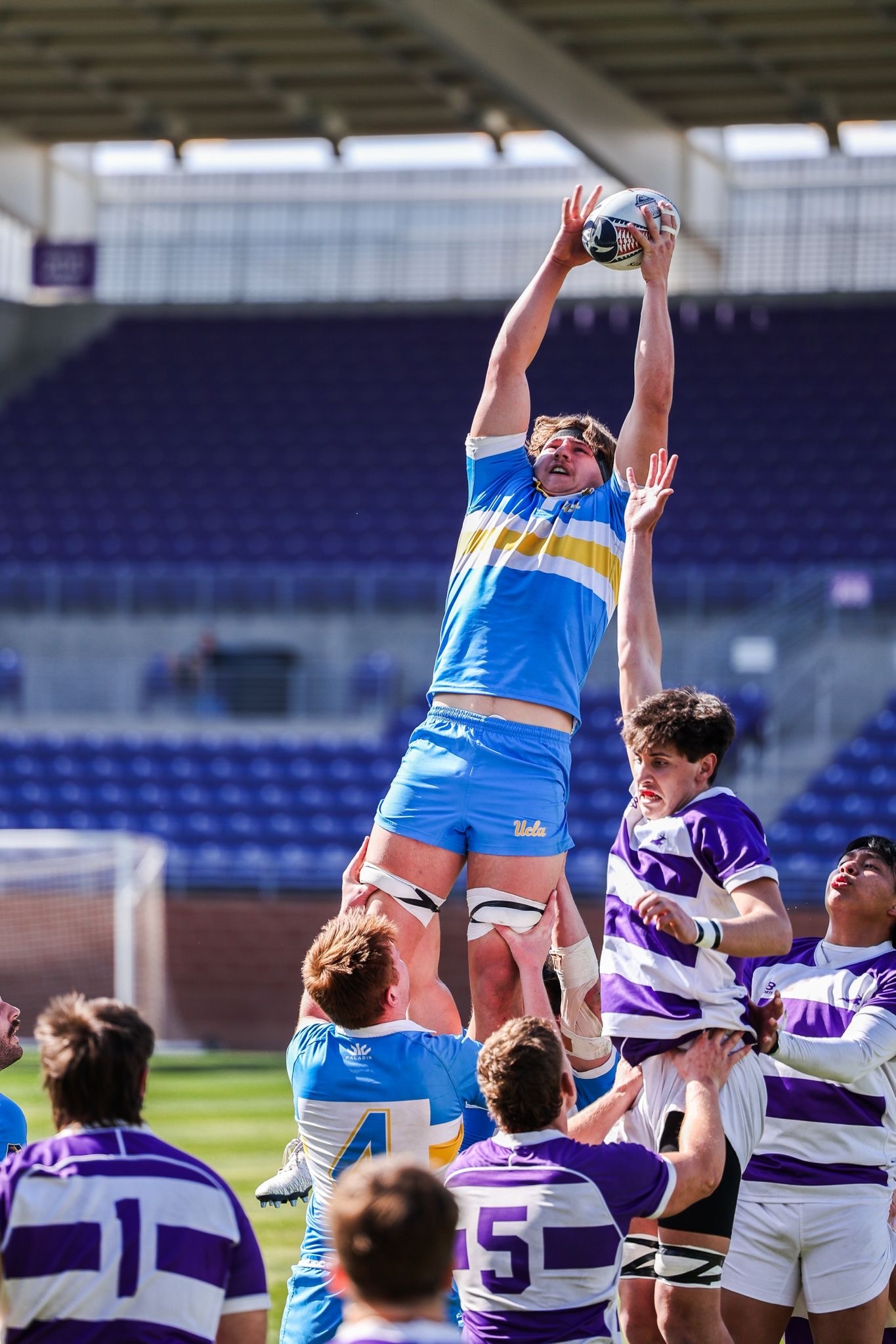 Sherman is hoisted up by his teammates as he catches the ball.