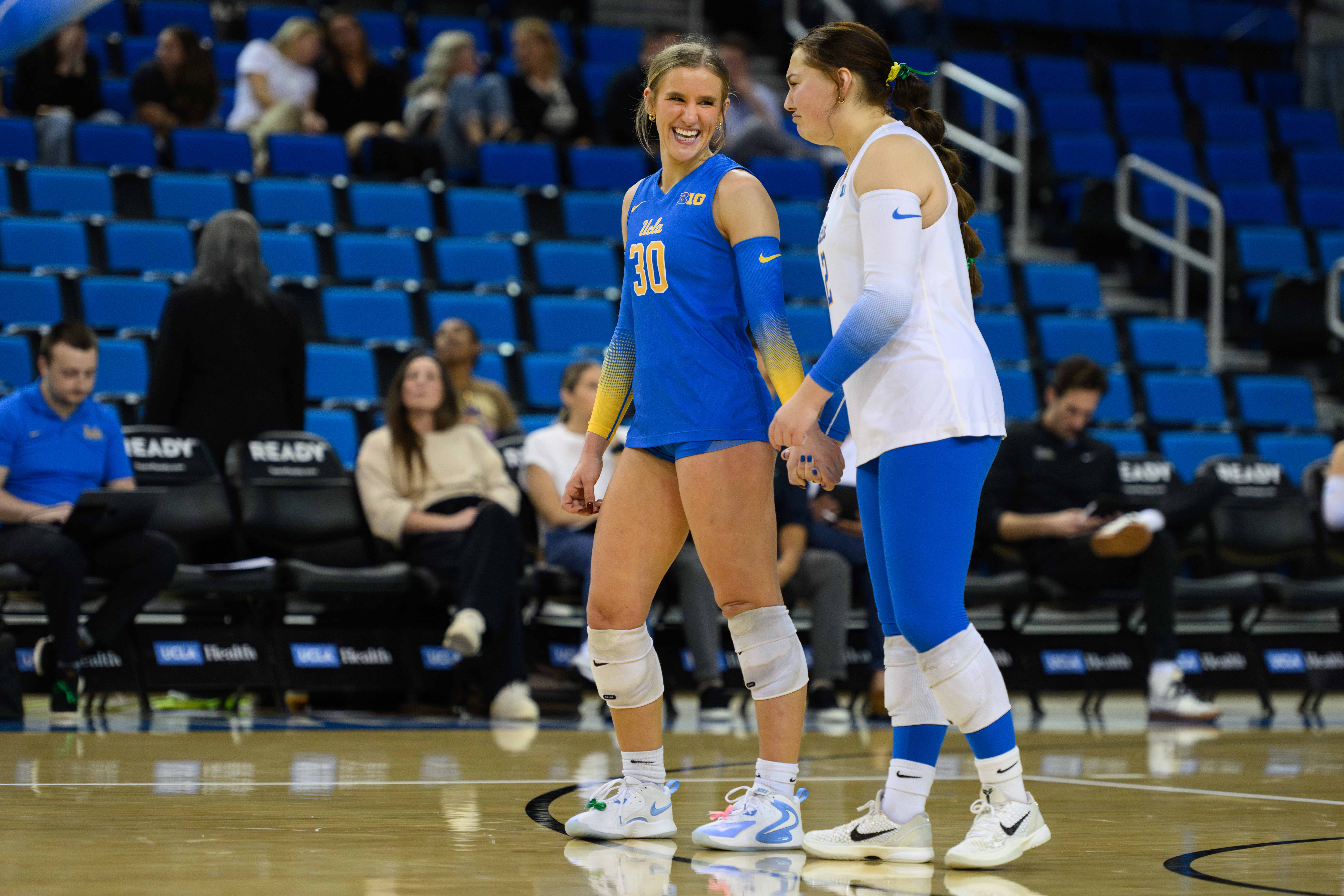 Sophomore libero Lola Schumacher smiles with freshman defensive specialist Sakura Codling as the two stand together. Schumacher leads the Big Ten with 4.32 digs per set. (Brianna Carlson/Daily Bruin staff)