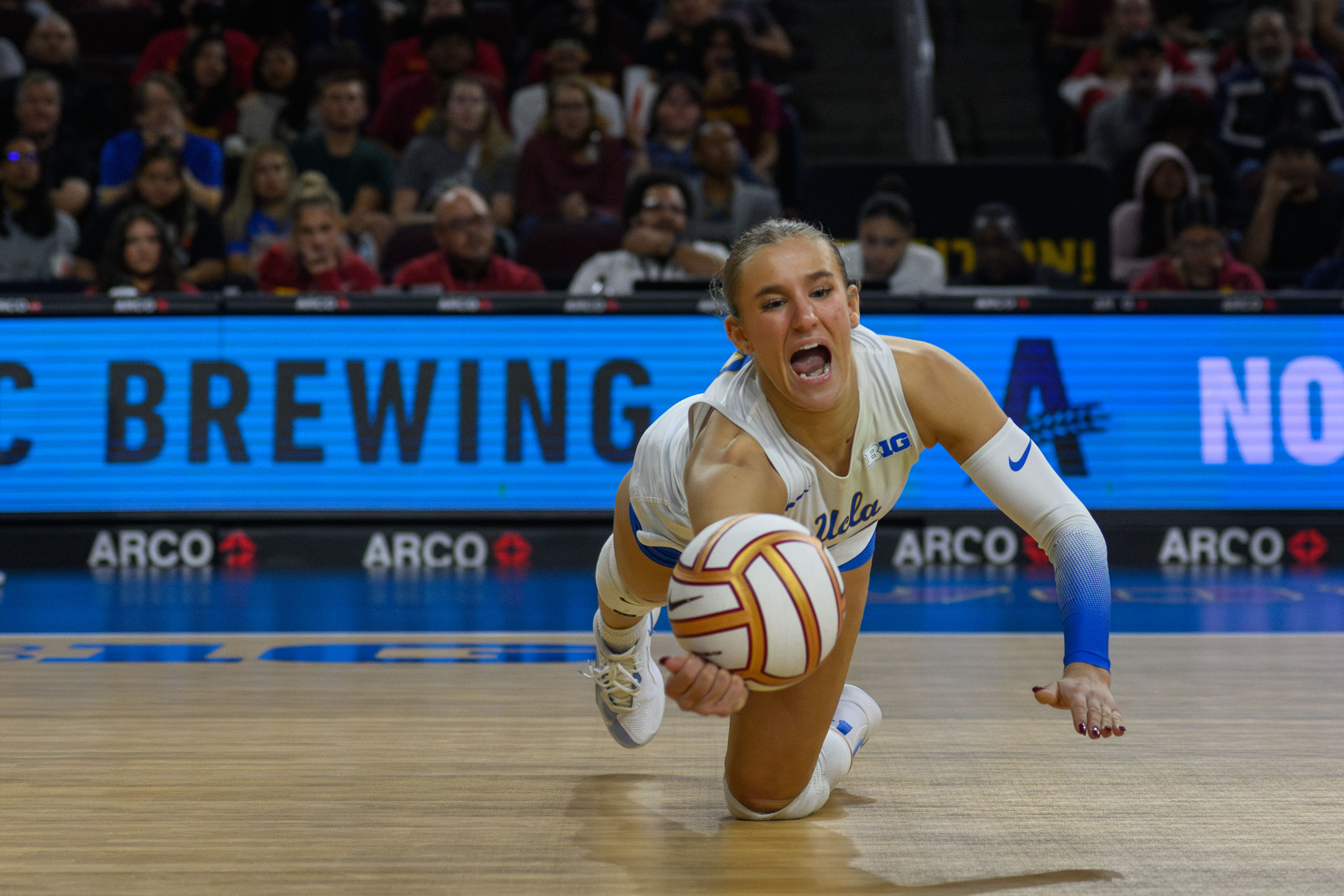 Sophomore defensive specialist/libero Lola Schumacher dives and gets the ball up with a one-handed dig. (Brianna Carlson/Daily Bruin staff)