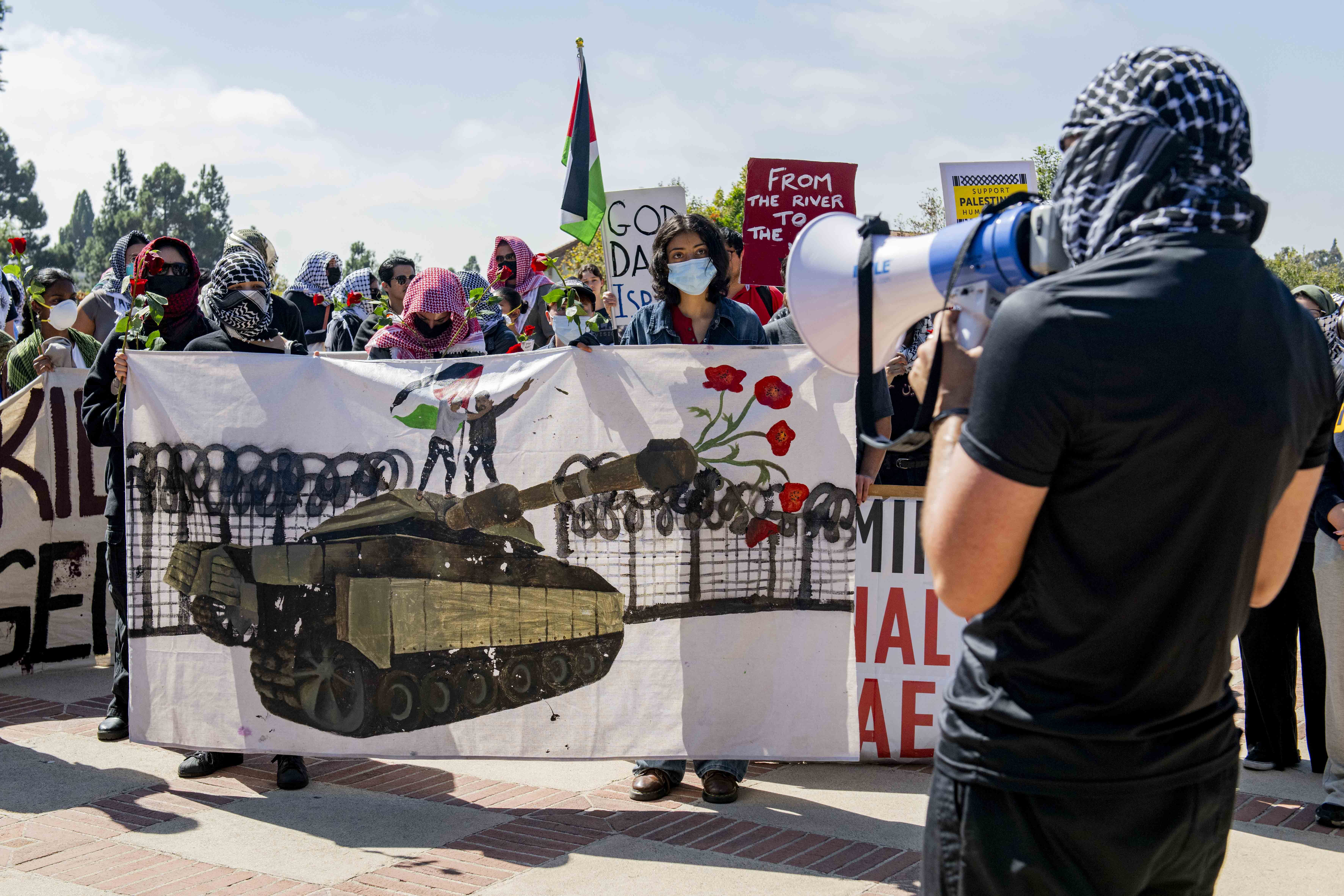 A student protester speaks to a crowd. Around 70 people attended a protest led by Students for Justice in Palestine at UCLA on Tuesday afternoon that commemorated two years since the start of Israel’s military campaign in Gaza. (Andrew Ramiro Diaz/Photo editor)