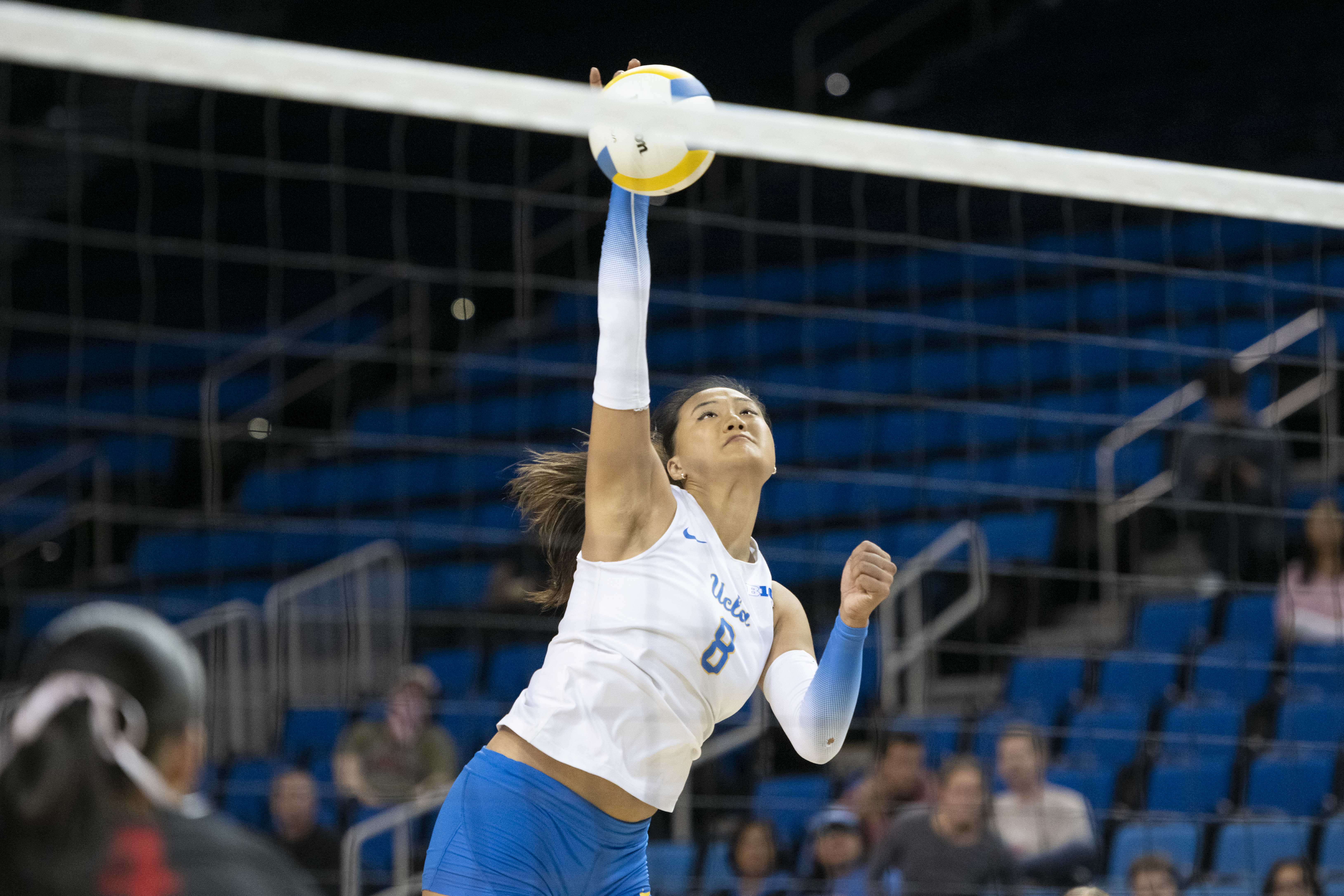 Junior outside hitter Maggie Li jumps and swings to hit the ball. (Edward Ho/Daily Bruin)