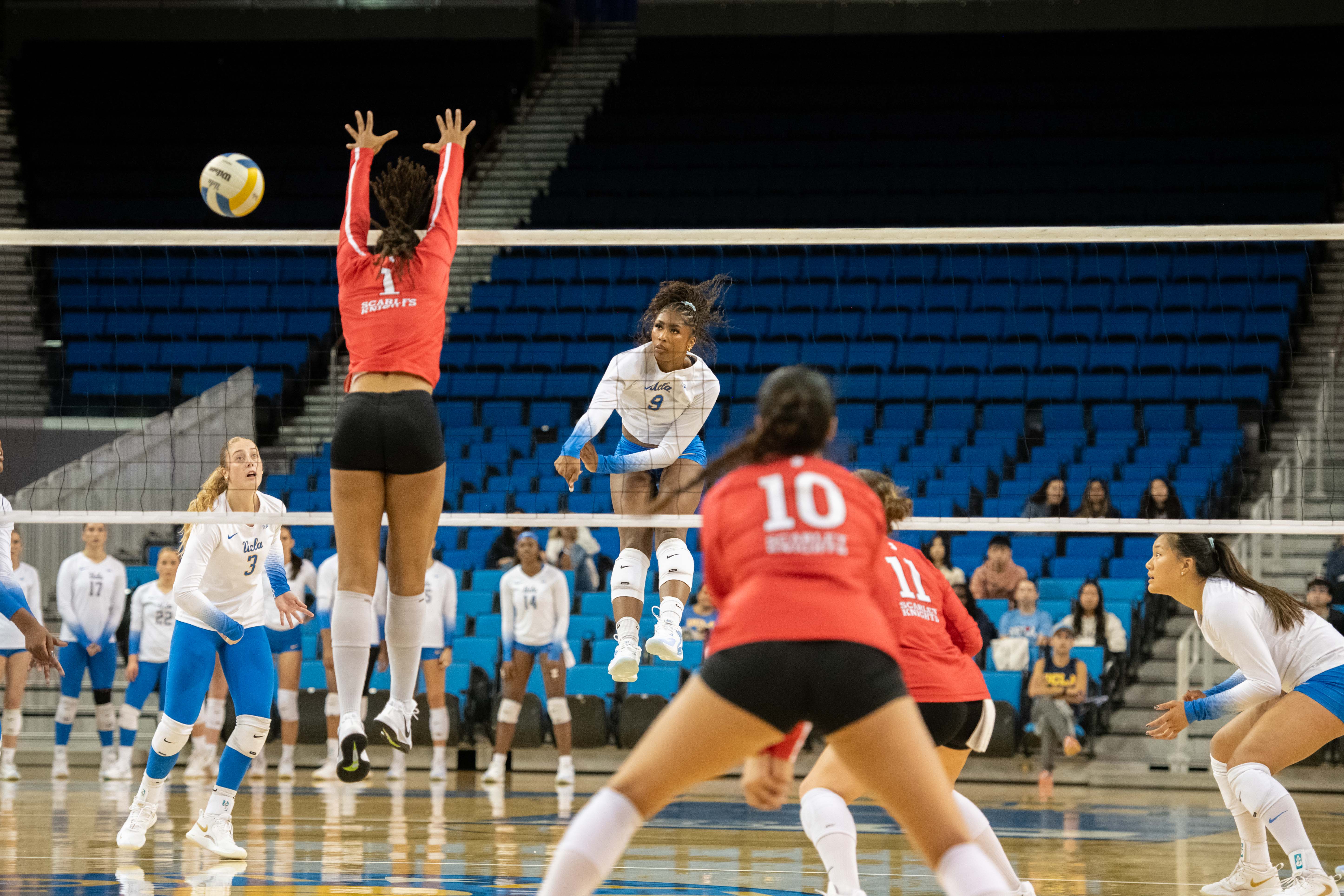 Senior outside hitter Cheridyn Leverette swings and hits the ball away from the Rutgers blocker. (Chenrui Zhang/Daily Bruin)