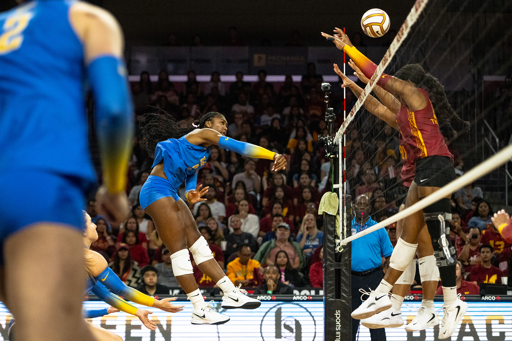 Senior outside hitter Cheridyn Leverette swings and hits the ball over the opposing team's blockers. (Zimo Li/Daily Bruin senior staff)