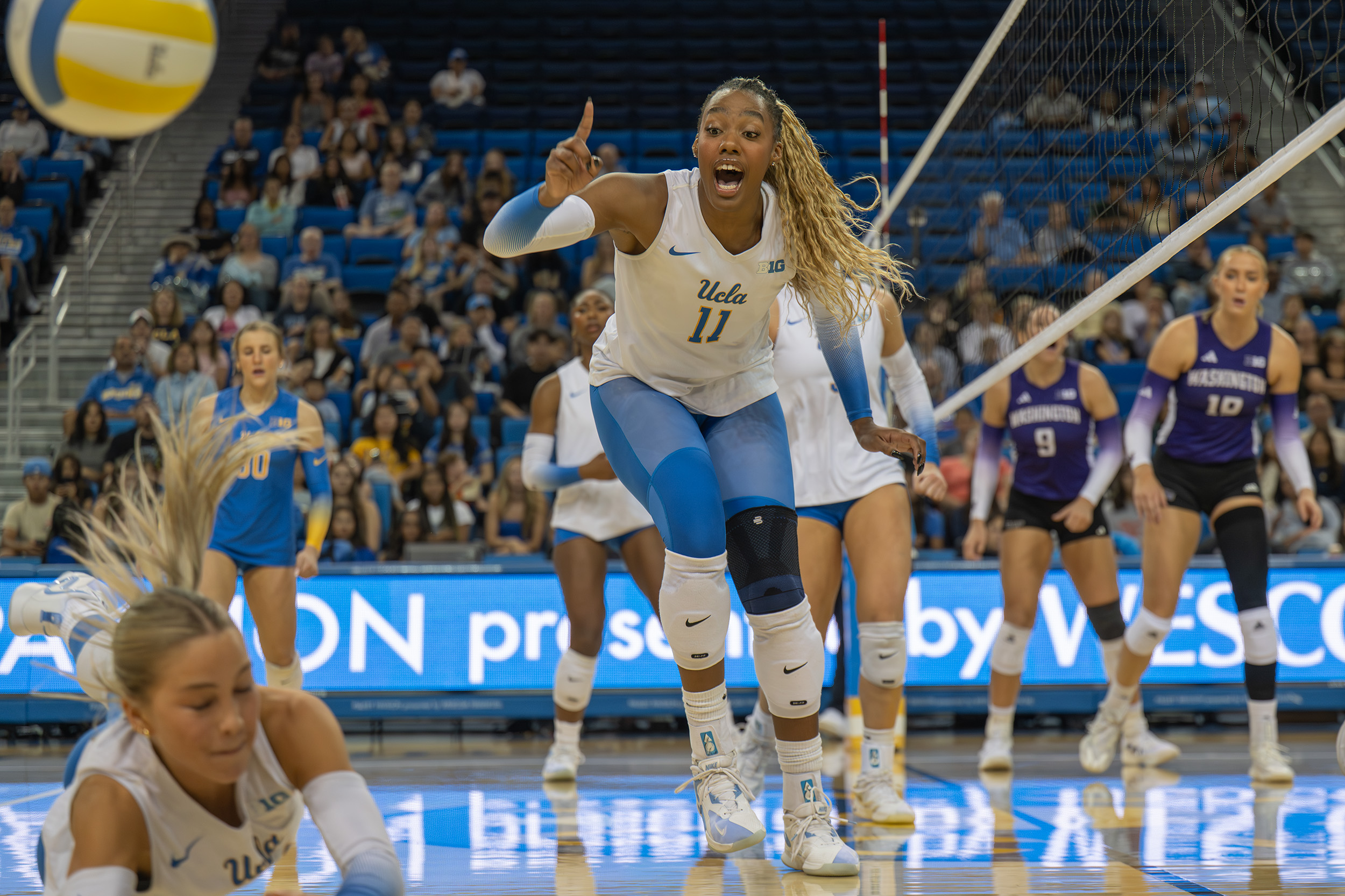 Singletary points up as her teammate digs the ball. (Tszshan Huang/Daily Bruin)