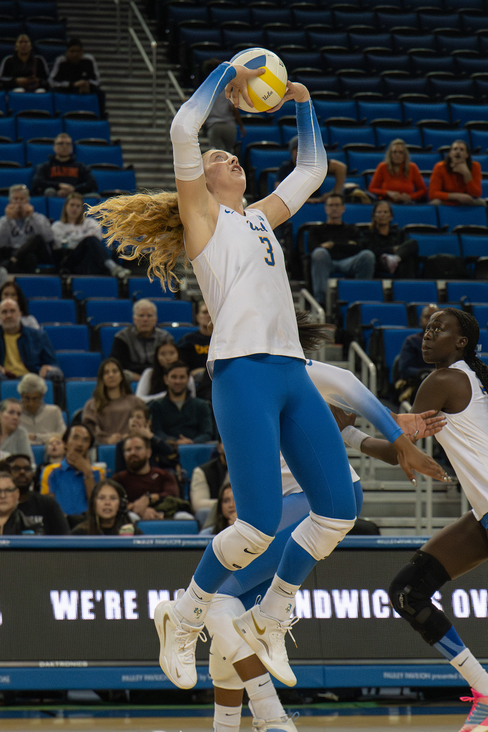 Sophomore setter Kate Duffey jumps and begins to back set the ball. (Vanessa Man/Daily Bruin)