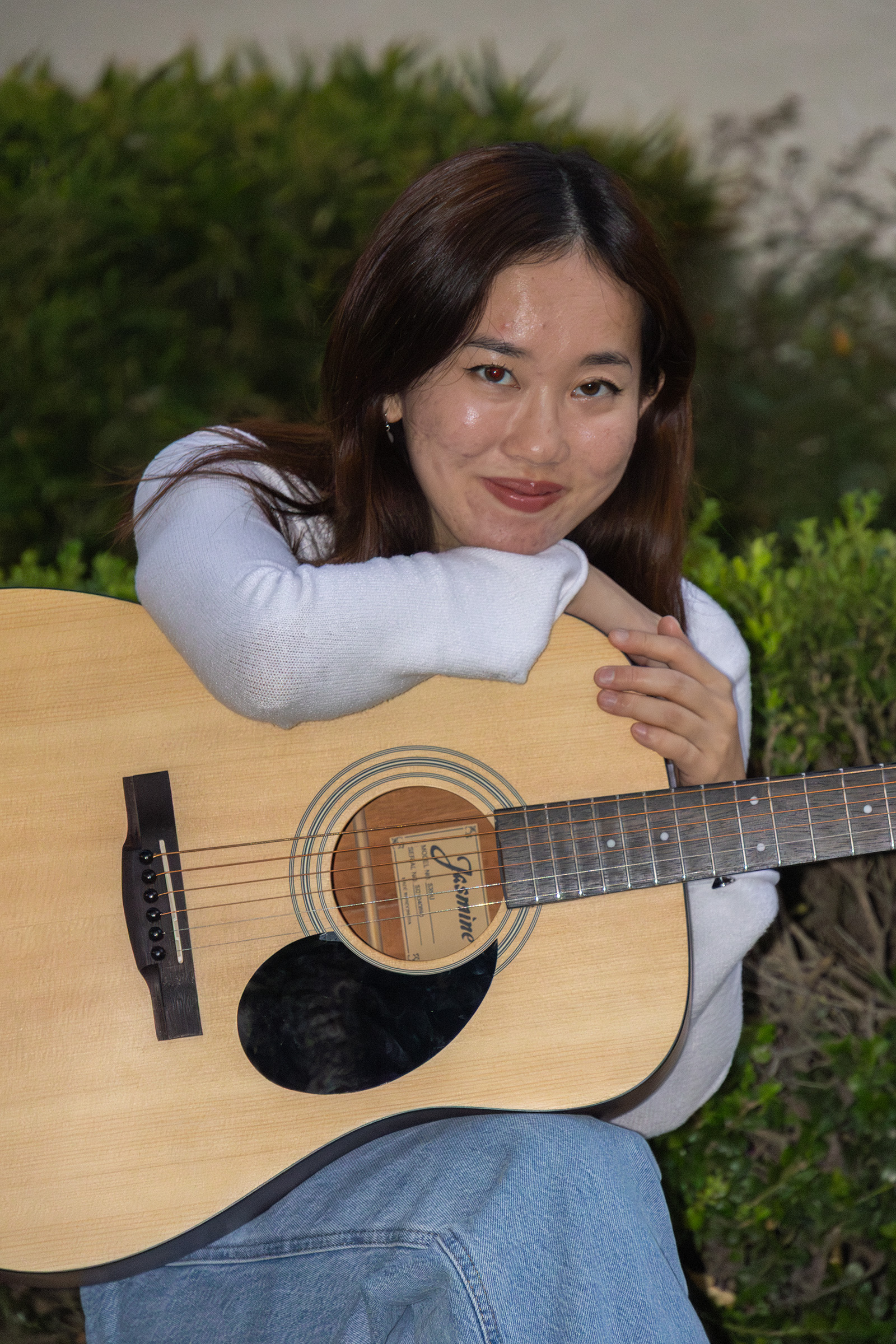 Pictured is Chu sitting with a guitar and leaning over it. The student said her creative process often occurs in solitude, as she processes her feelings through her writing. (Selin Filiz/Assistant Photo editor)