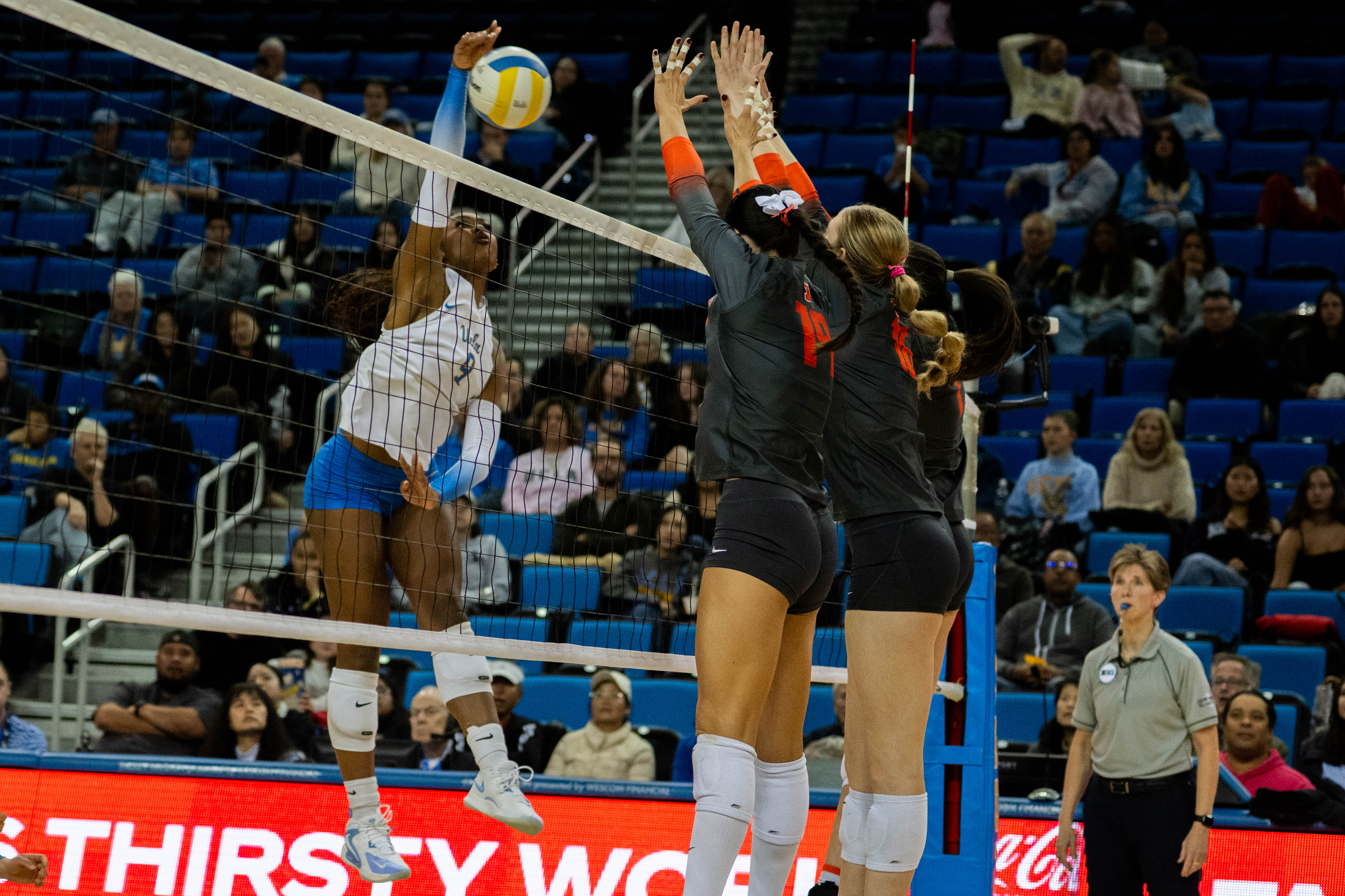 Senior outside hitter Cheridyn Leverette jumps and hits the ball away from the Rutgers blockers. Leverette posted 18 kills against Georgia Tech in the Bruins' first round of the NCAA tournament.(Max Zhang/Daily Bruin staff)
