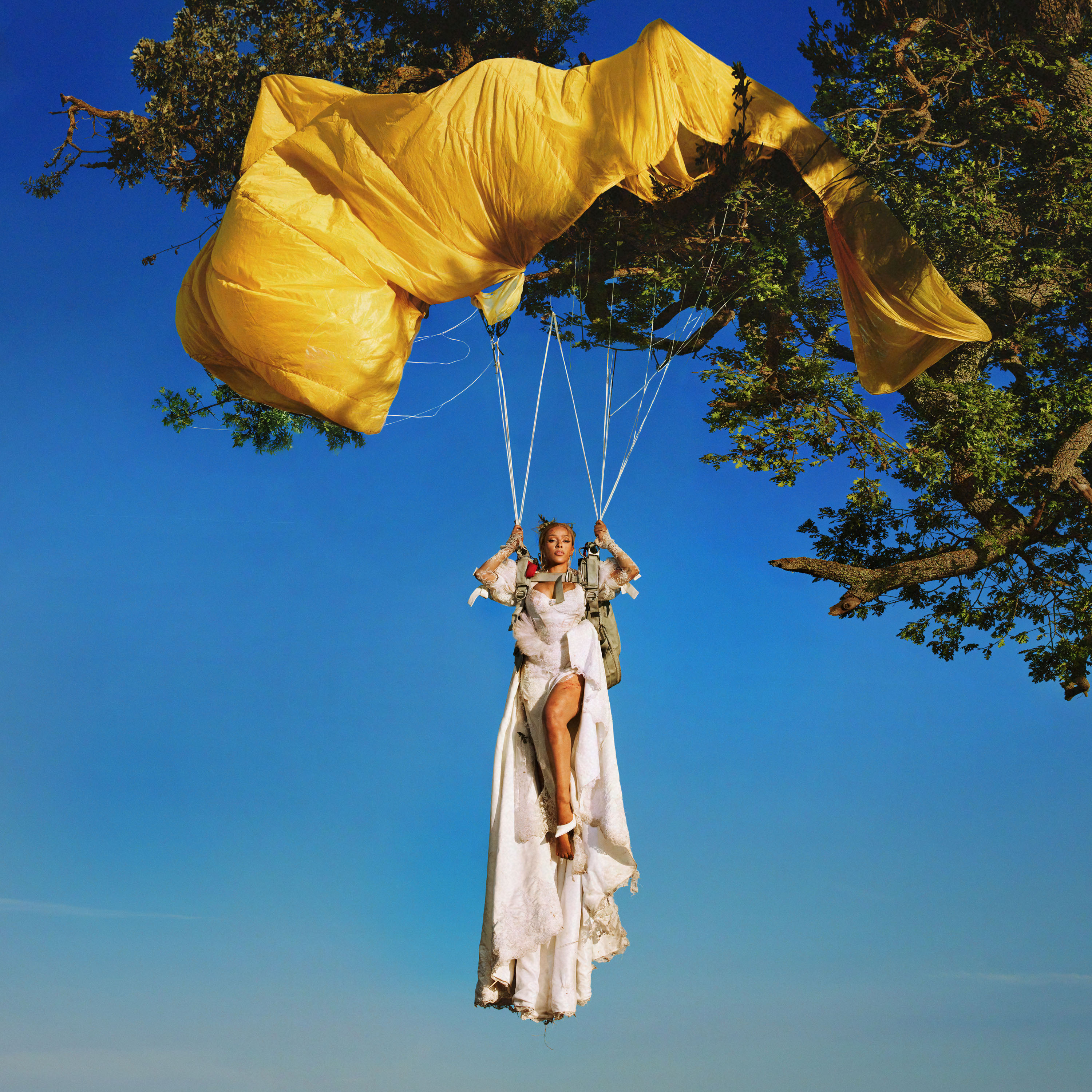 Doja Cat hangs from a yellow parachute trapped in a tree, while wearing a white wedding gown for the album cover of her fifth album, "Vie." The artist&squot;s latest music video depicts her falling in love and closes with an unexpected open ending.(Courtesy of Kemosabe Records/RCA Records)