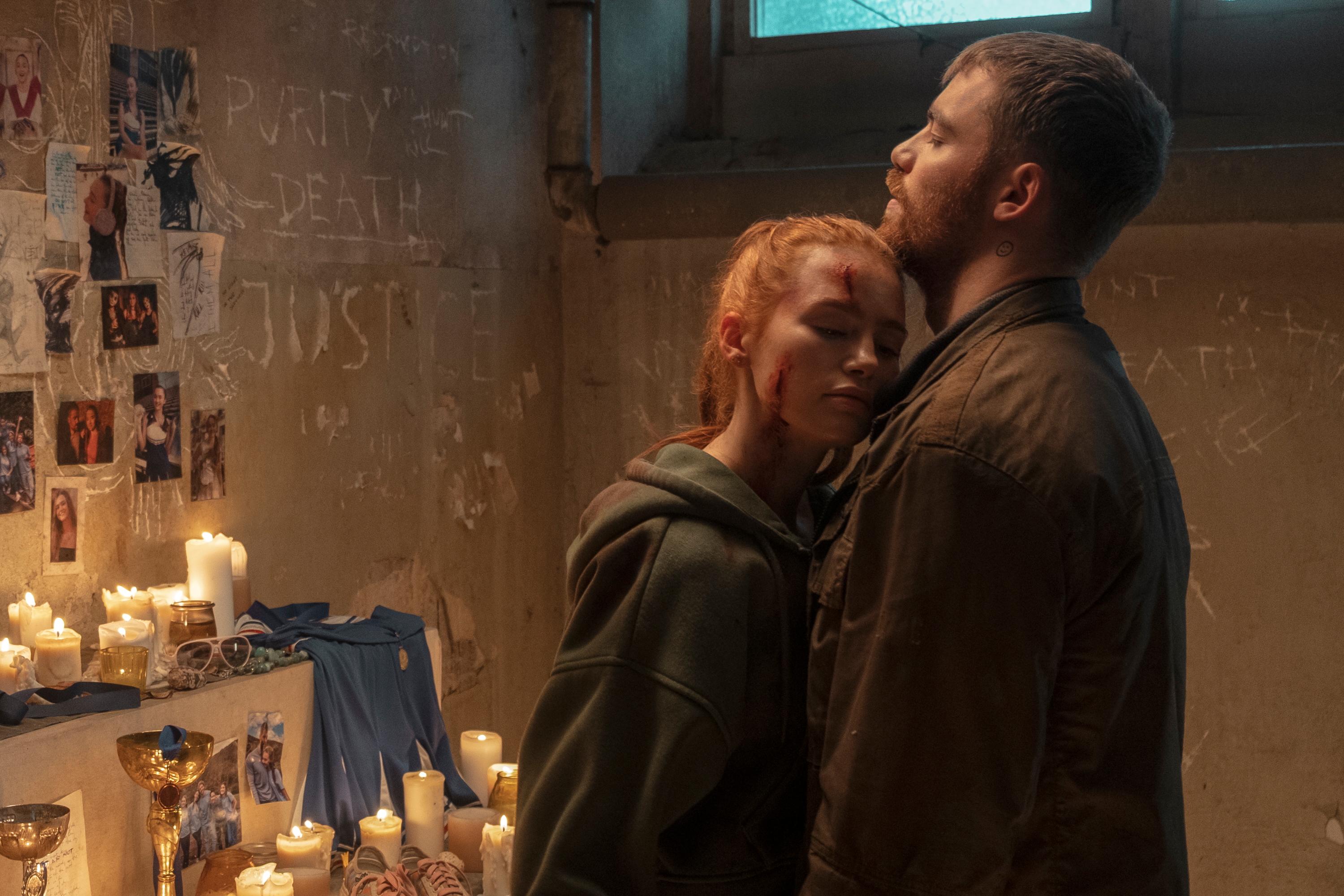 Maya (Madelaine Petsch) and Gregory (Gabriel Basso) are pictured standing close together with lit candles and photographs in the background. “The Strangers: Chapter 3” was released in theaters Feb. 6. (Courtesy of Lionsgate)