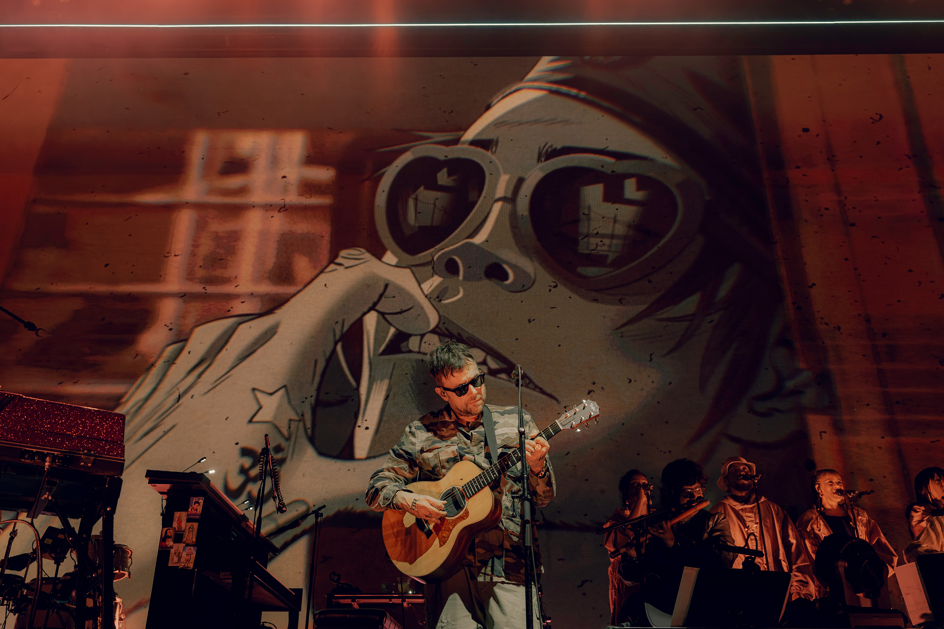 Standing on the center stage playing an acoustic guitar is Albarn. The Hollywood Palladium show featured the entirety of Gorillaz&squot;s new album, "The Mountain," as well as an encore directed to long-time fans. (Courtesy of Blair Brown)