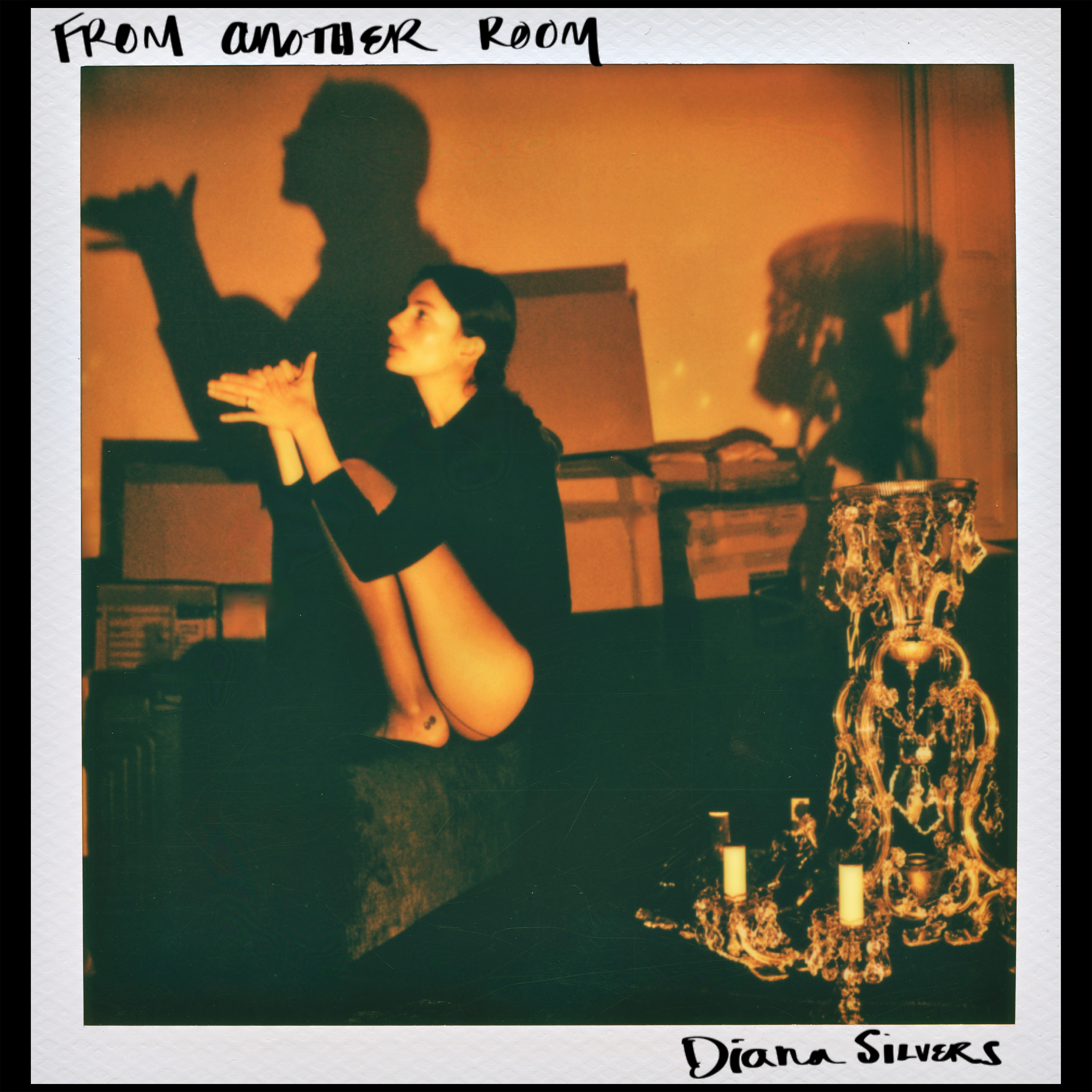 Pictured is a polaroid-like picture of Diana Silvers sitting on the armrest of a couch, doing a shadow animal with her hands, while warm light casts over her. The actress-turned-singer released her debut album, "From Another Room," in November 2025 (Courtesy of Coyote Records, Inc., under exclusive license to UMG Recordings, Inc.)