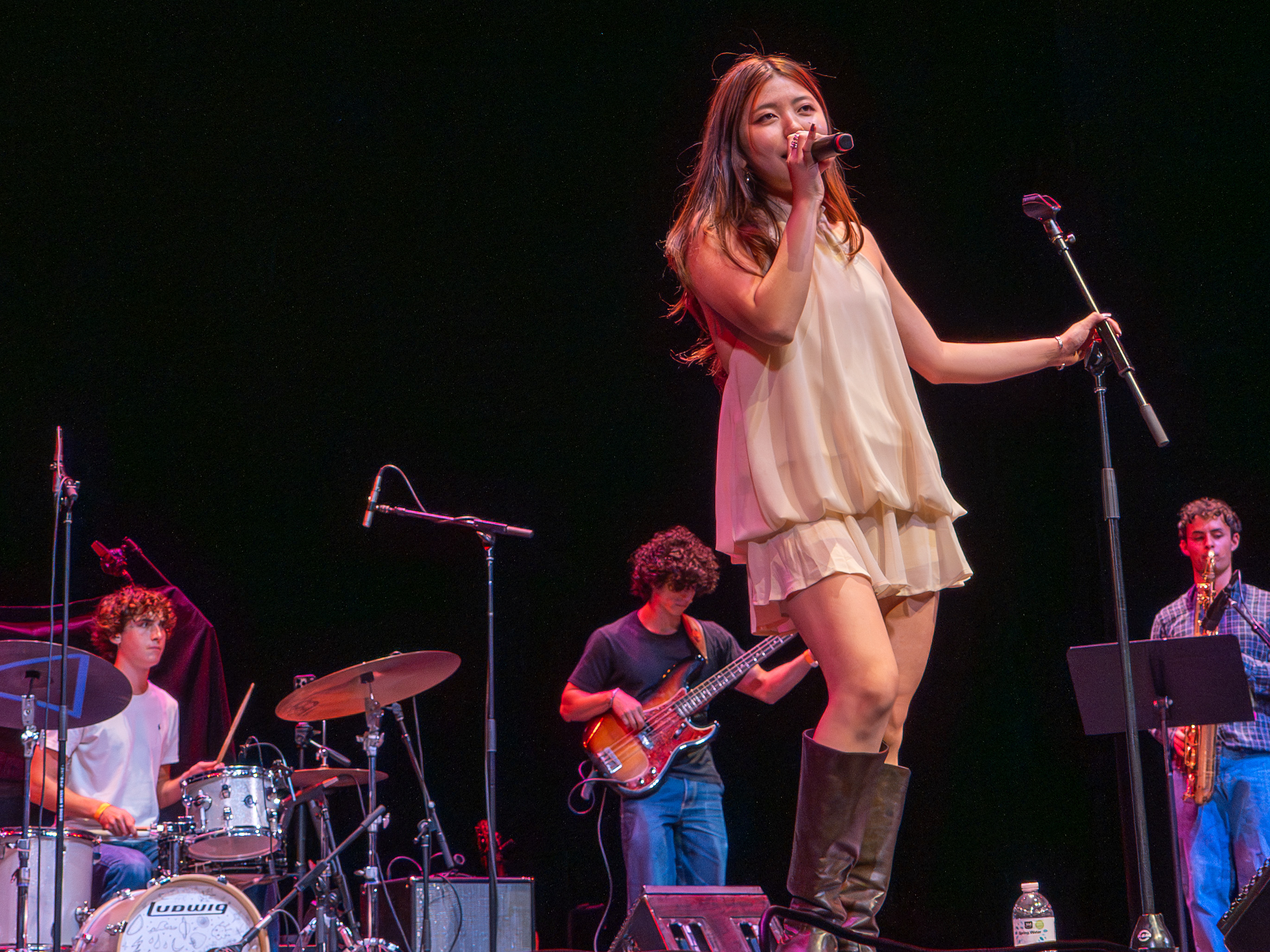 Cocona Mori, a performer and fourth-year music industry student, sings, surrounded by band members. The music industry student opened the event. (Maanasi Kademani/Daily Bruin)