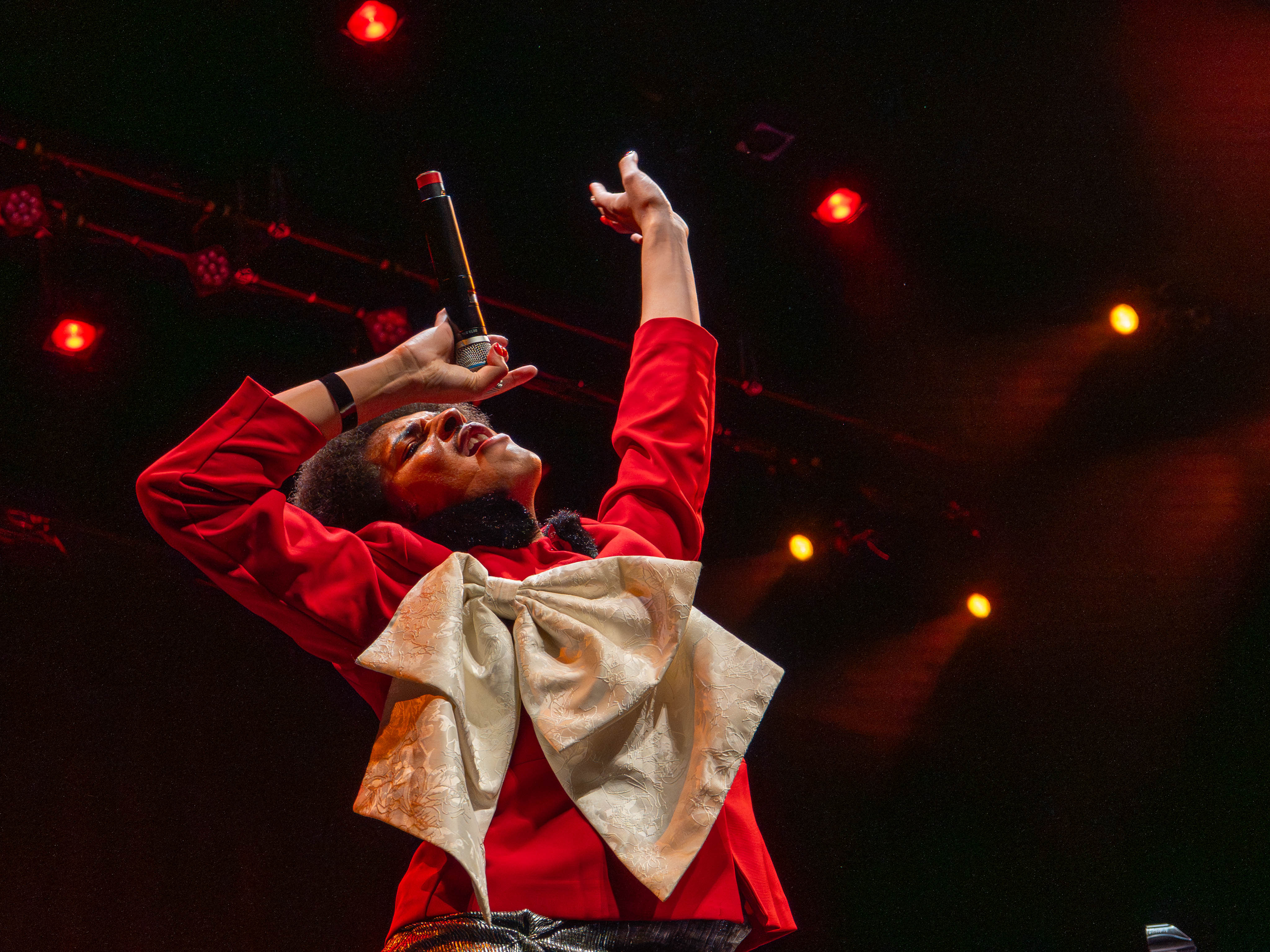 Issac Dunbar belts into a microphone as he raises an arm to the ceiling. Dunbar played songs such as “Princess,” “fan behavior” and “Tainted Love” at the event. (Maanasi Kademani/Daily Bruin)