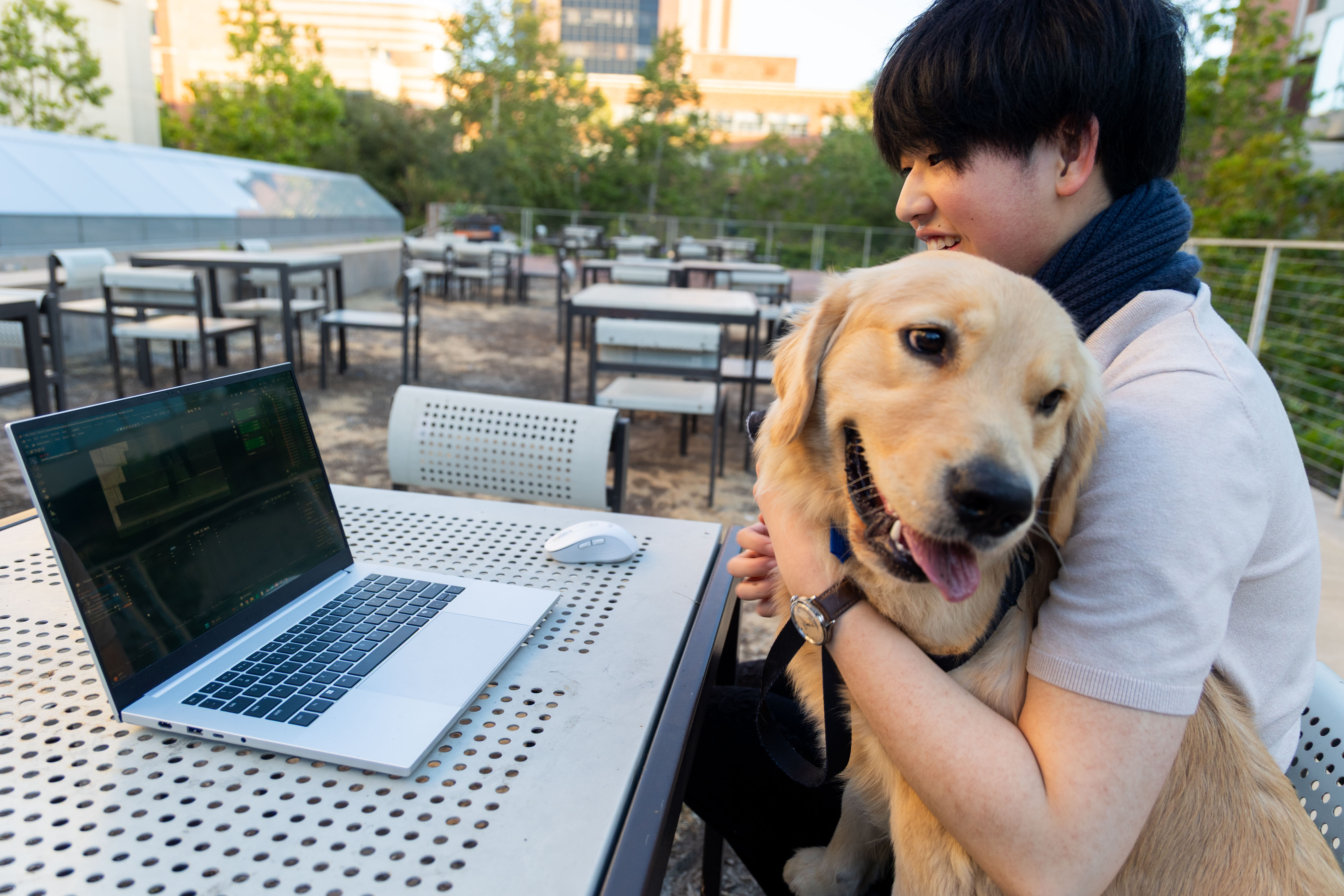 Su looks at a laptop while holding his dog. The process for his animation starts with a story concept and then moves to the free 3D software Blender – a process that Su does out of his dorm room. (William Gauvin/Daily Bruin staff)