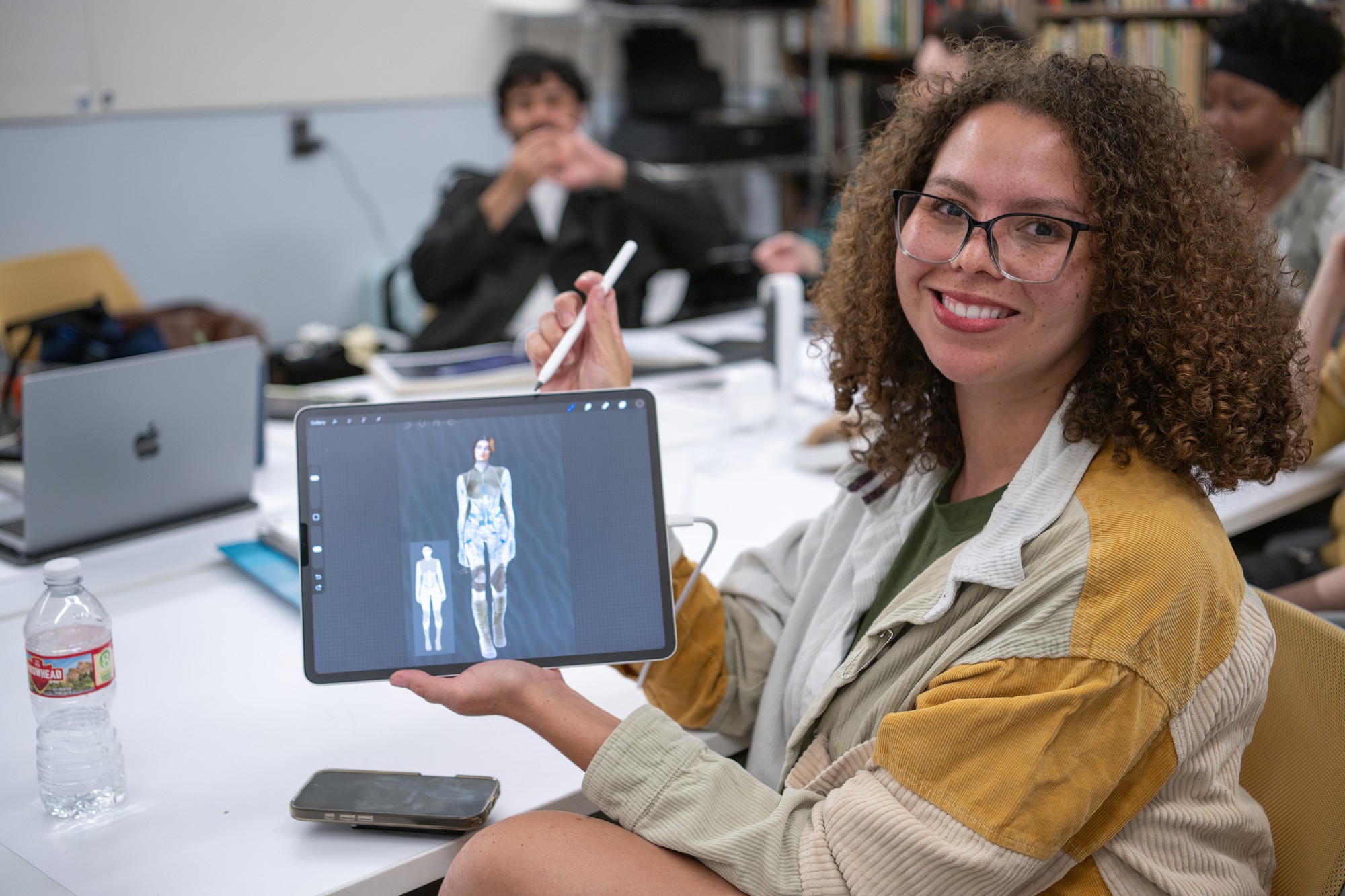 Caprice Shirley holds up a costume design on an iPad. West&squot;s newest class focuses on her work for "Dune" and "Dune: Part Two." (Presley Liu/Daily Bruin)