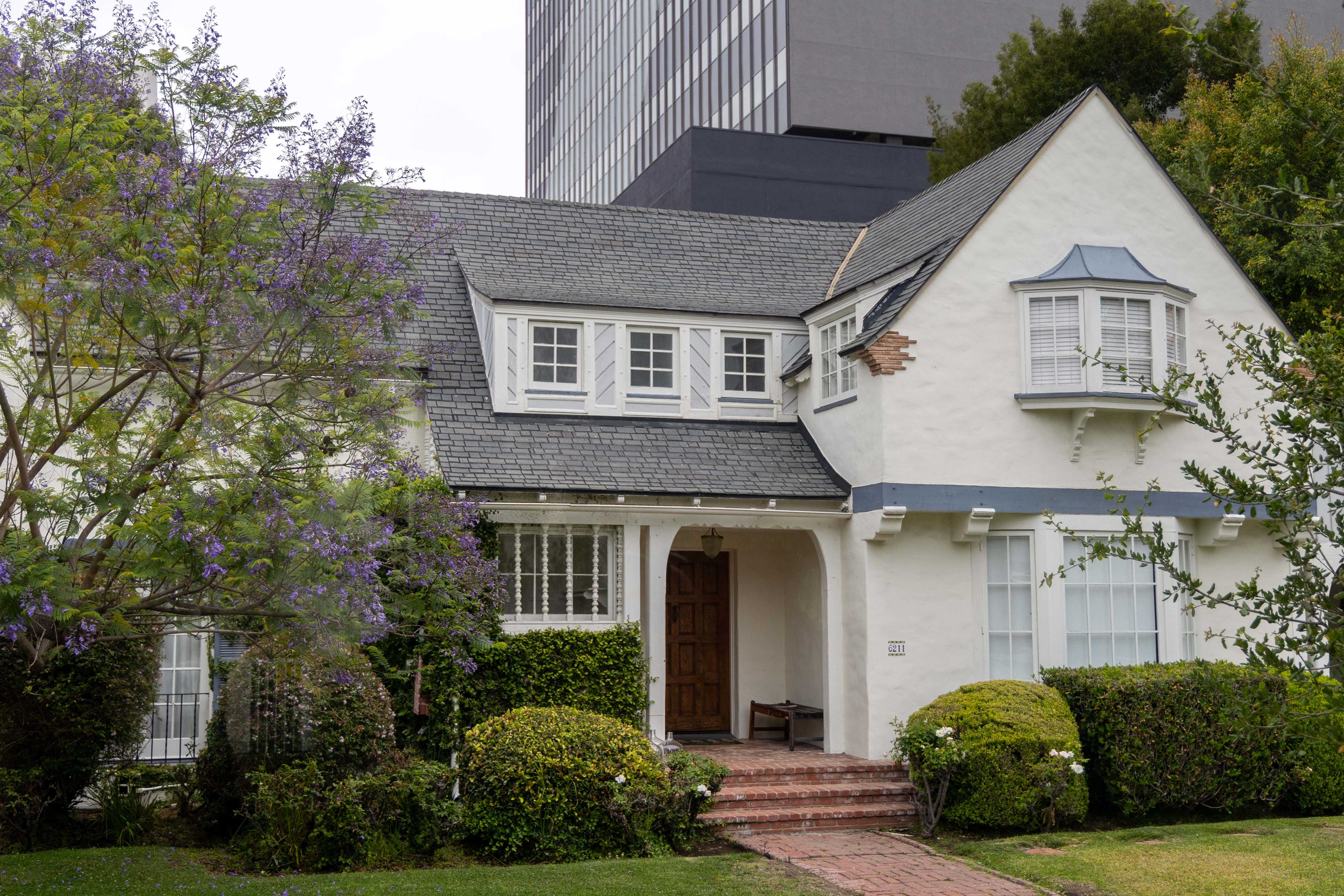 The Podcast House stands against an LA skyscraper with manicured lawns. A notable location from the television show, "Nobody Wants This," it features on the filming locations tour. (Chenrui Zhang/Daily Bruin staff)