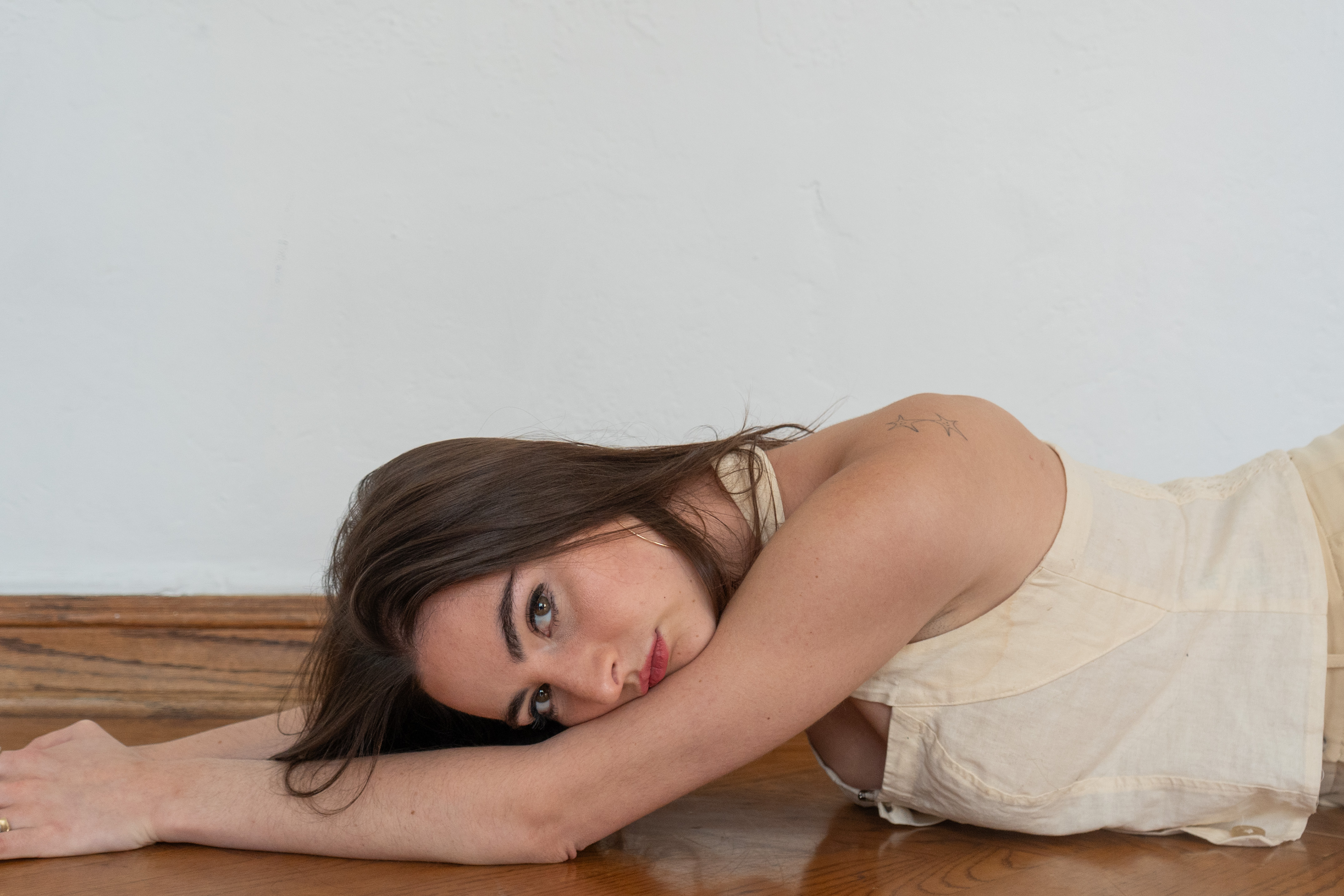 Zager is lying down on the floor, looking to the side. For her audition process, Zager said she recreated her childhood bedroom, referencing the place where she has written many of her songs. (Maanasi Kademani/Daily Bruin)