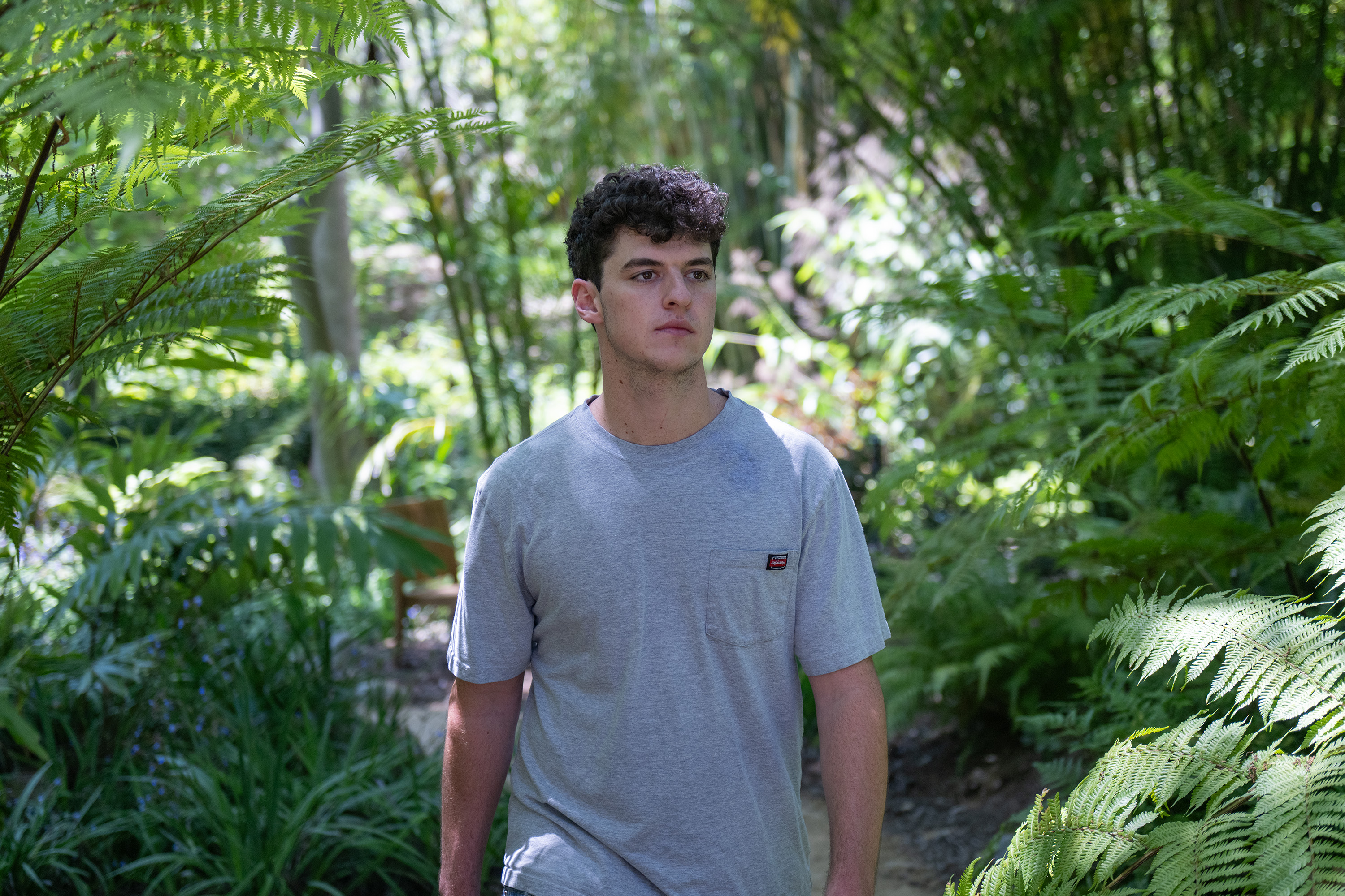 Salamy walking through a path at the UCLA Mathias Botanical Garden, wearing a gray t-shirt. The business economics student said he strives for his music to be as authentic as possible, stepping away from the formulaic pop-country genre.  (Purvi Singhania/Daily Bruin)
