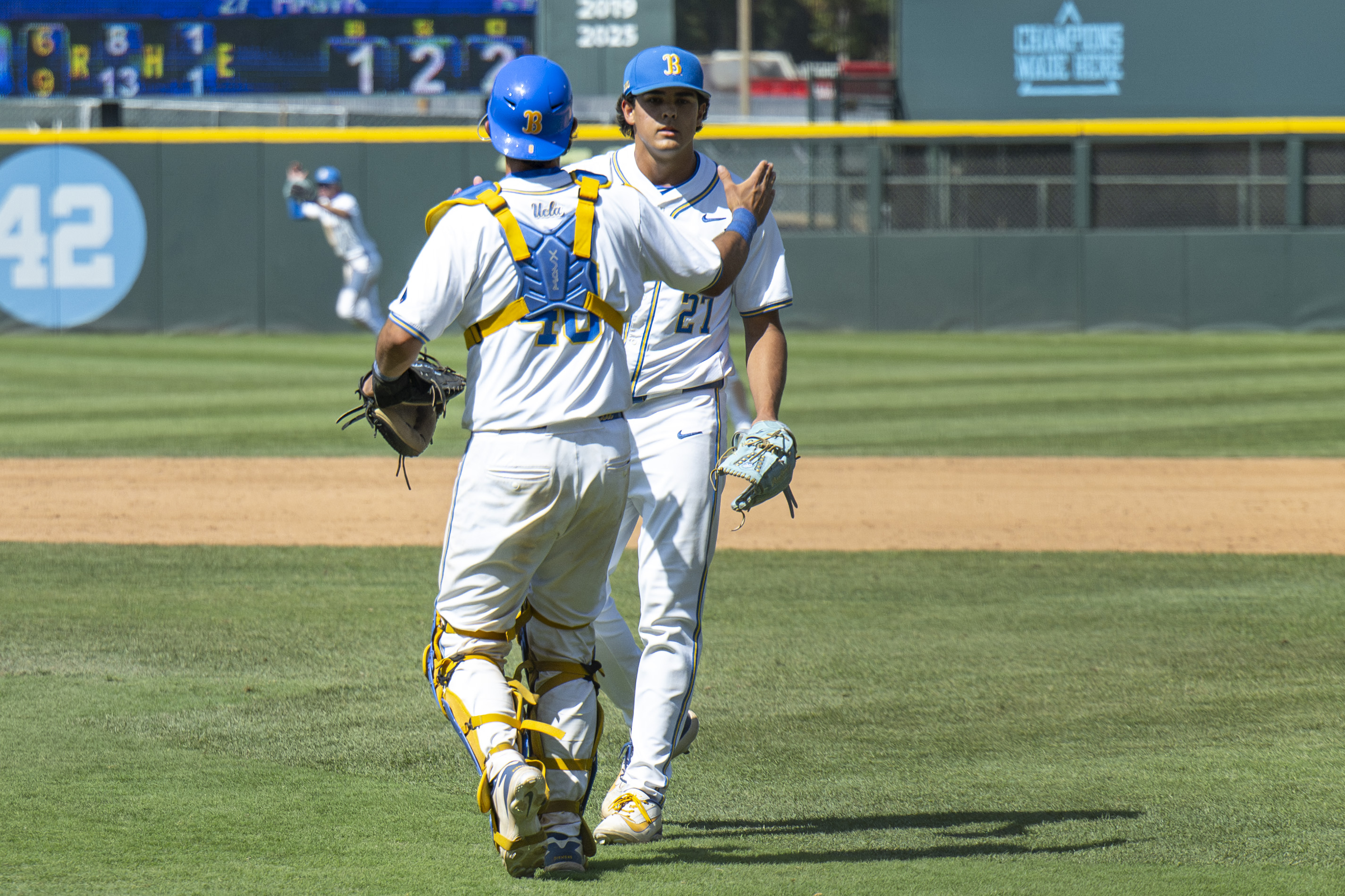 Sophomore right-hander Easton Hawk (right) and junior catcher Cashel Dugger (left) meet in the infield after the end of Sunday's game against Oregon. (Kai Dizon/Daily Bruin senior staff)