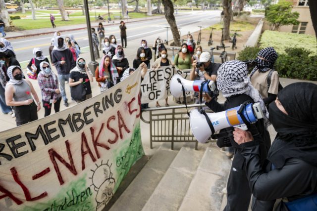 Members of Students for Justice in Palestine at UCLA protest outside Murphy Hall, where the offices of UCLA administrators are located. About 35 people marched on campus Friday to commemorate the 59th anniversary of the 1967 Naksa. (Andrew Ramiro Diaz/Photo editor)