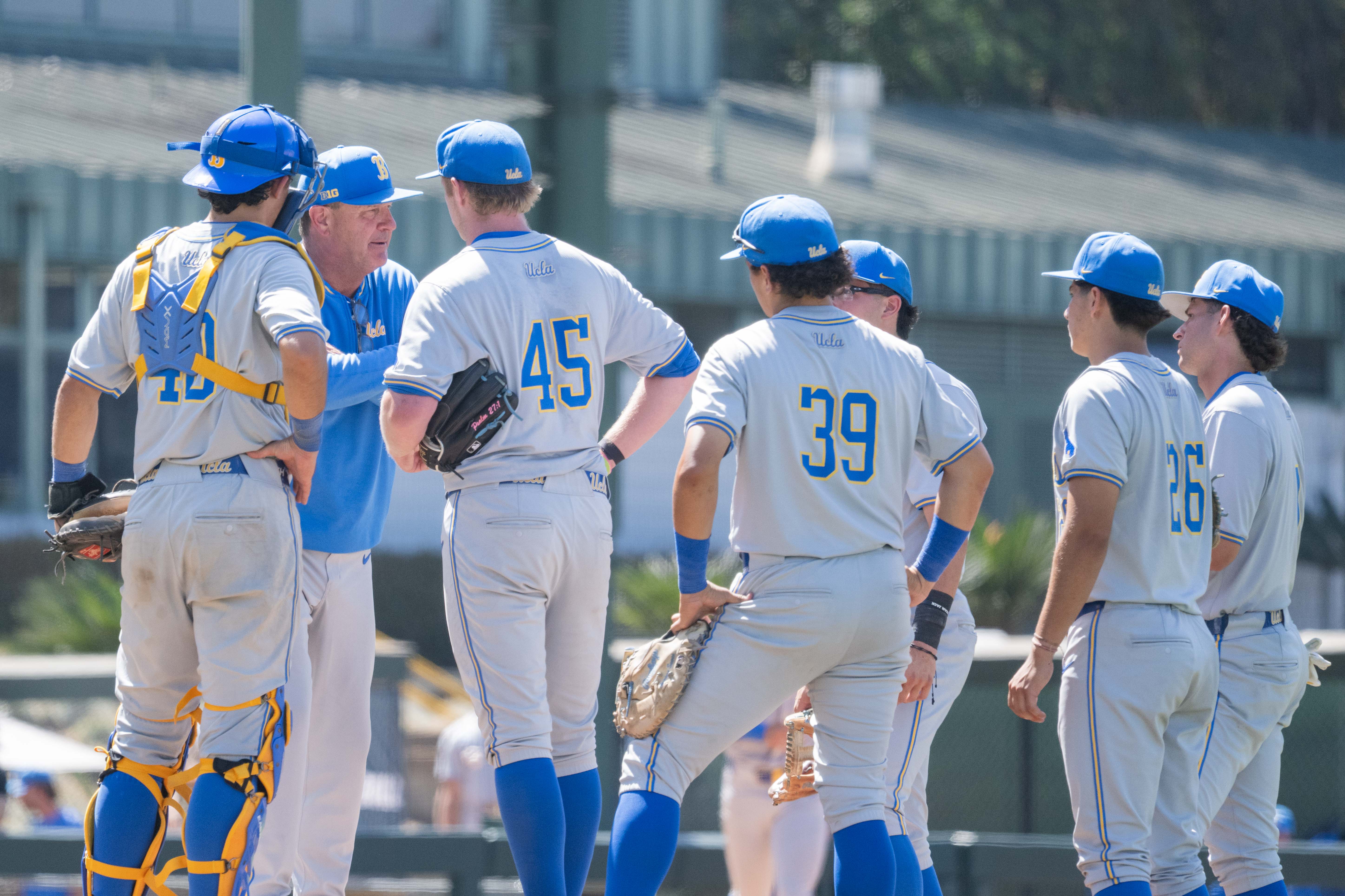 Savage (second from left) meets with his infield on the mound. (Kai Dizon/Assistant Photo editor)