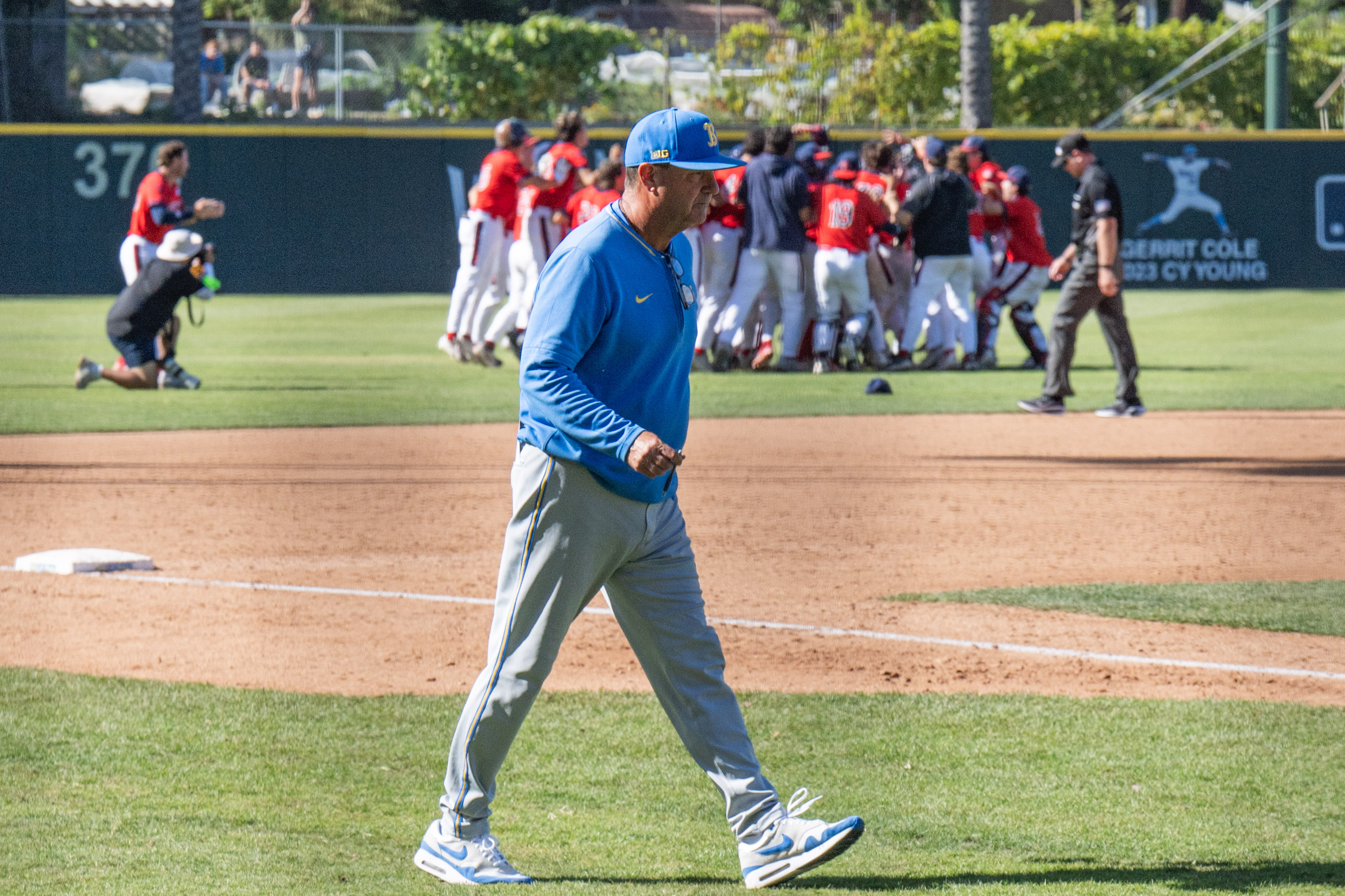 Savage walks toward home plate while Saint Mary's celebrates its walk-off victory in the outfield. (Leydi Cris Cobo Cordon/Daily Bruin senior staff)