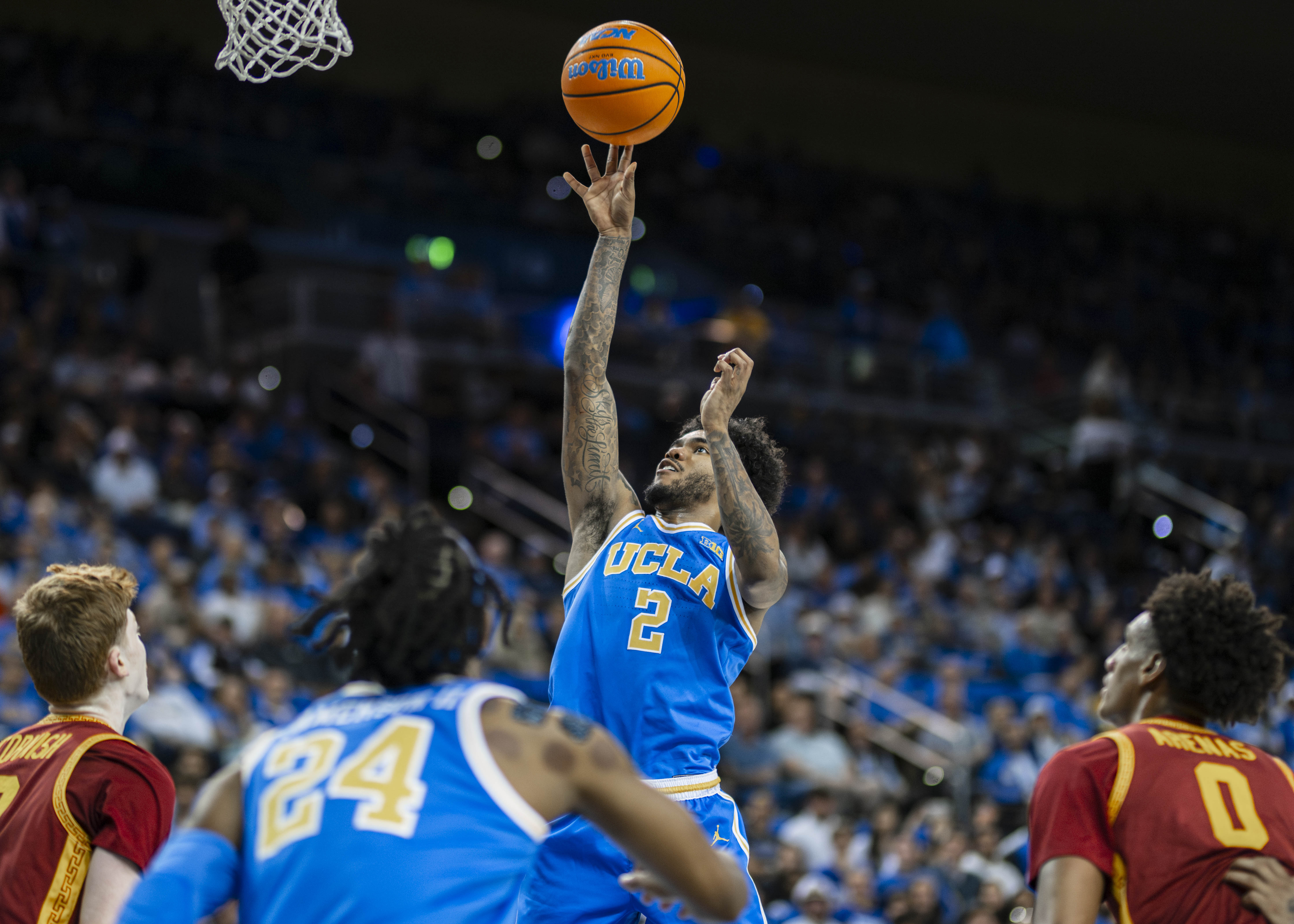 Senior point guard Donovan Dent lays the ball up at the rim. Dent helped lead UCLA men's basketball to the second round of the NCAA tournament. (Aidan Sun/Daily Bruin senior staff)