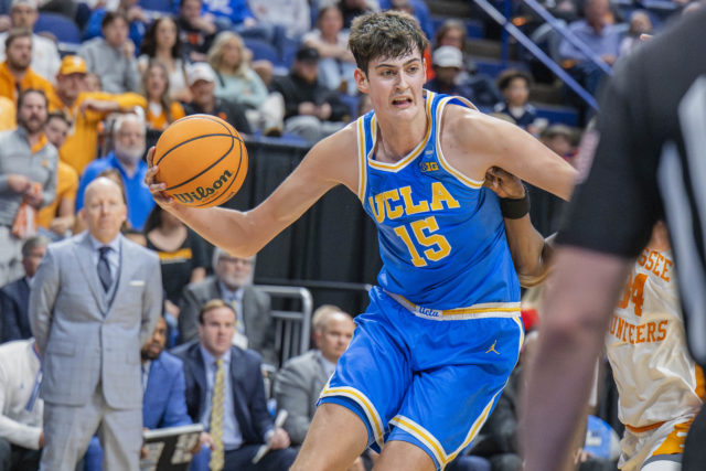 Former UCLA men’s basketball center Aday Mara dribbles by an opposing defender. Mara was drafted 12th overall by the Oklahoma City Thunder in the 2026 NBA Draft. (Zimo Li/Daily Bruin senior staff)