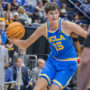 Former UCLA men’s basketball center Aday Mara dribbles by an opposing defender. Mara was drafted 12th overall by the Oklahoma City Thunder in the 2026 NBA Draft. (Zimo Li/Daily Bruin senior staff)