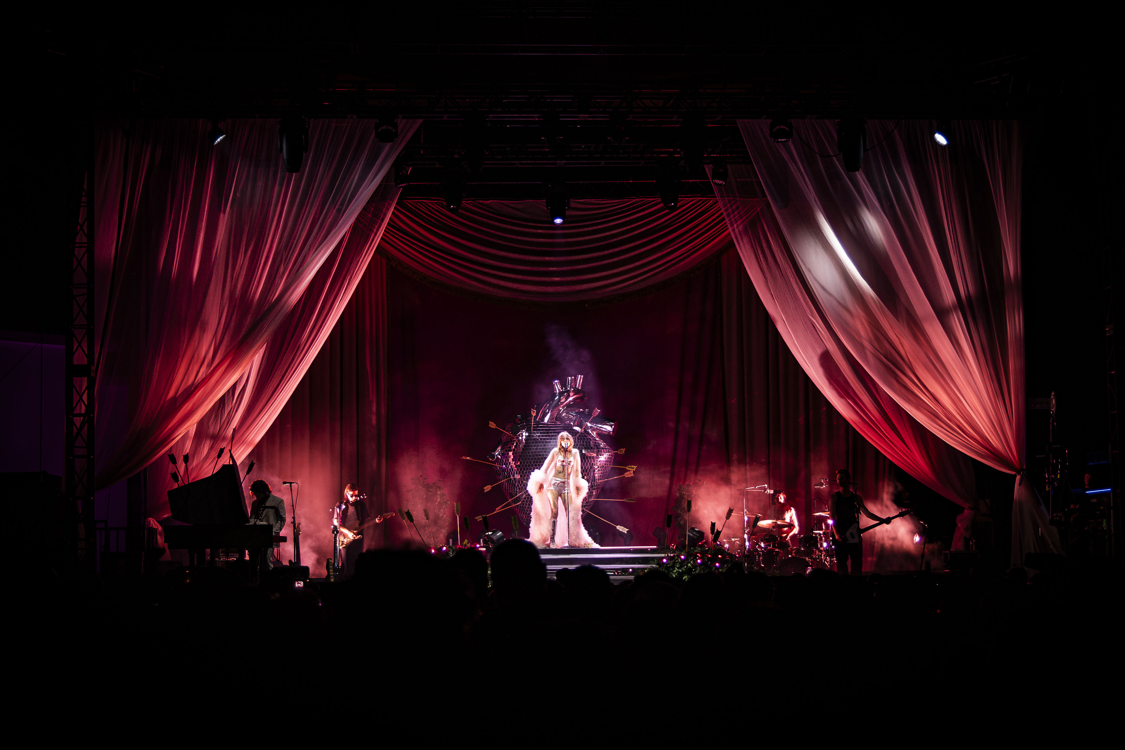 The singer is illuminated under red lighting in a feathery overthrow. The 90-minute set consisted of 20 songs mostly from her album “Loveland,” which came out July 10, along with hits from her previous two albums and EP. (Chenui Zhang/Daily Bruin staff)