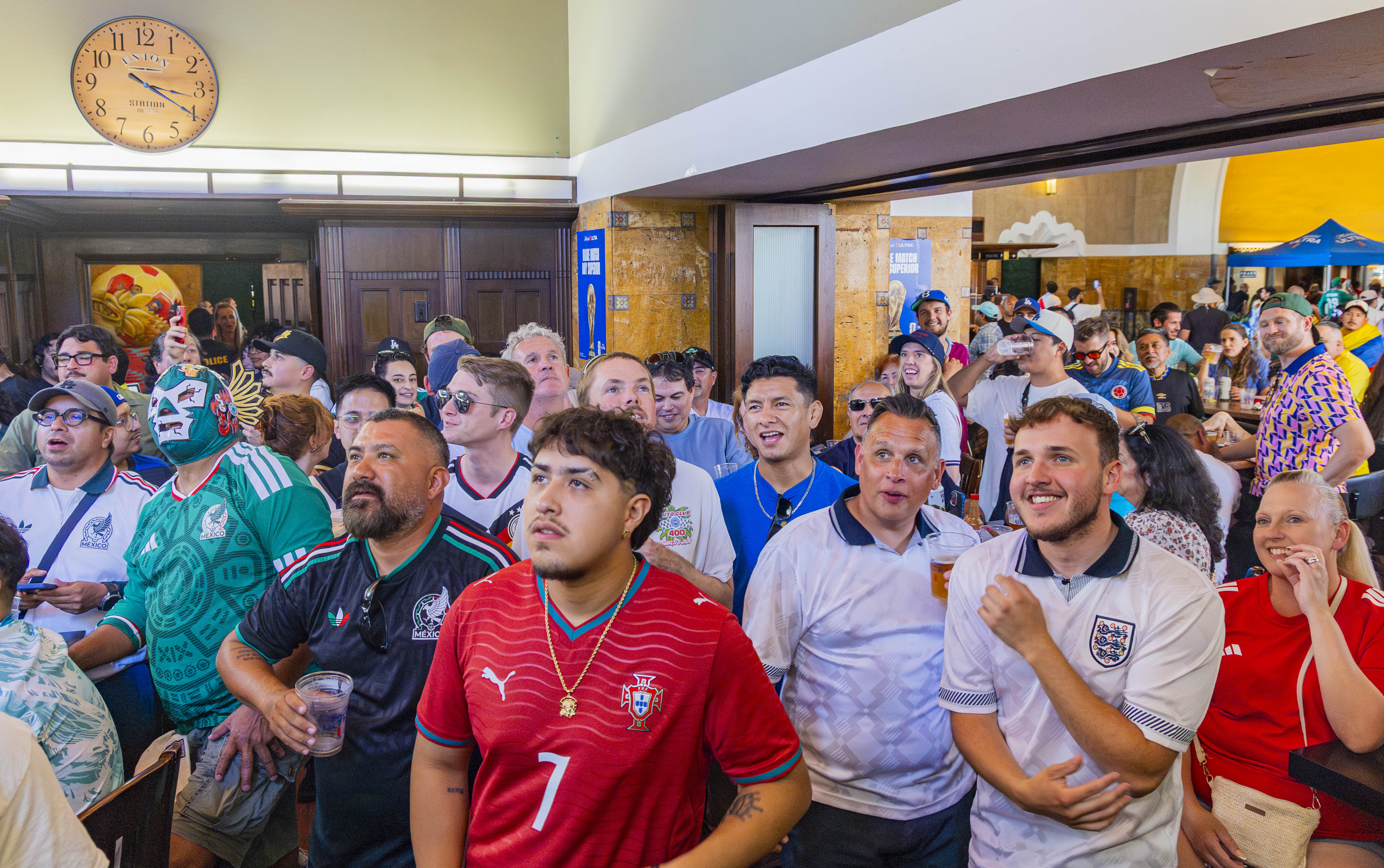 Fans, wearing kits that represent countries such as England and Mexico, gather together and watch the England-Panama match in Traxx Bar of Union Station. (Chenrui Zhang/Daily Bruin staff)