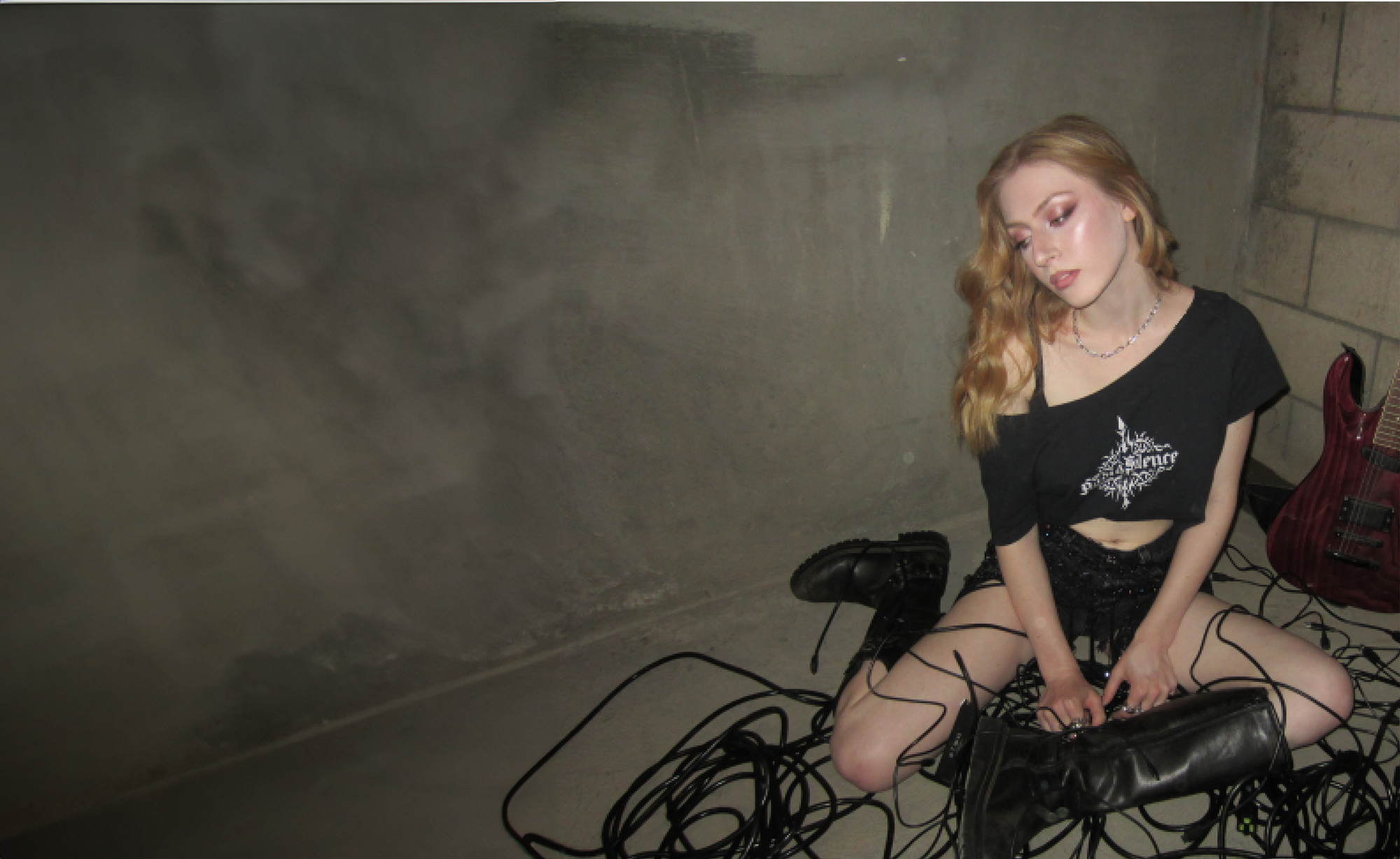 The singer/songwriter sits around cords in a concrete space. Whether it’s drawing inspiration from medieval documentaries or interpersonal relationships, Dove tells heartfelt stories with a danceable beat. (Courtesy of Garrison Morev)