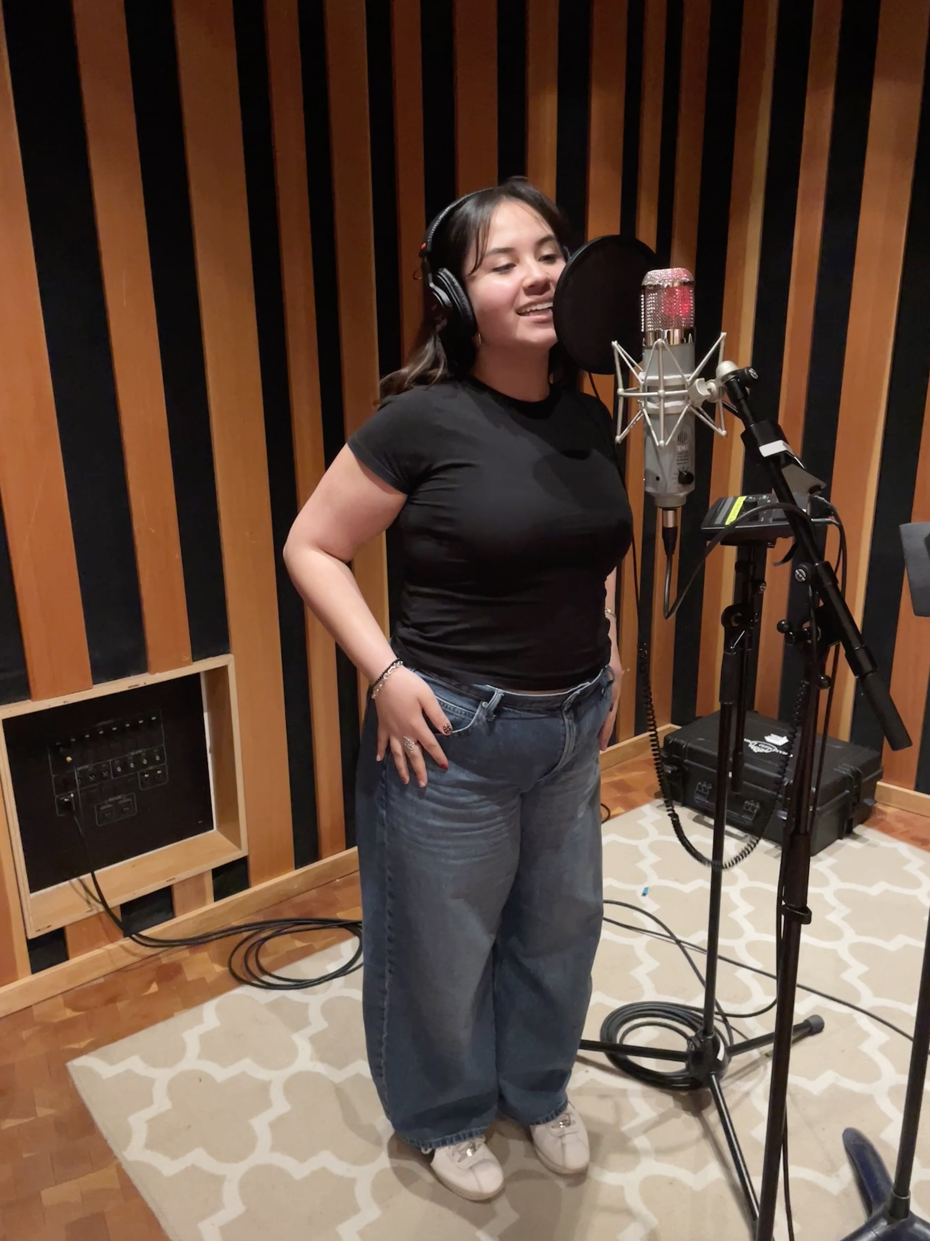 Contreras stands at a microphone in the recording studio at UCLA’s Evelyn and Mo Ostin Music Center, where the alumnus worked on the Hannah Montana-inspired EP. (Courtesy of Moriah Contreras)
