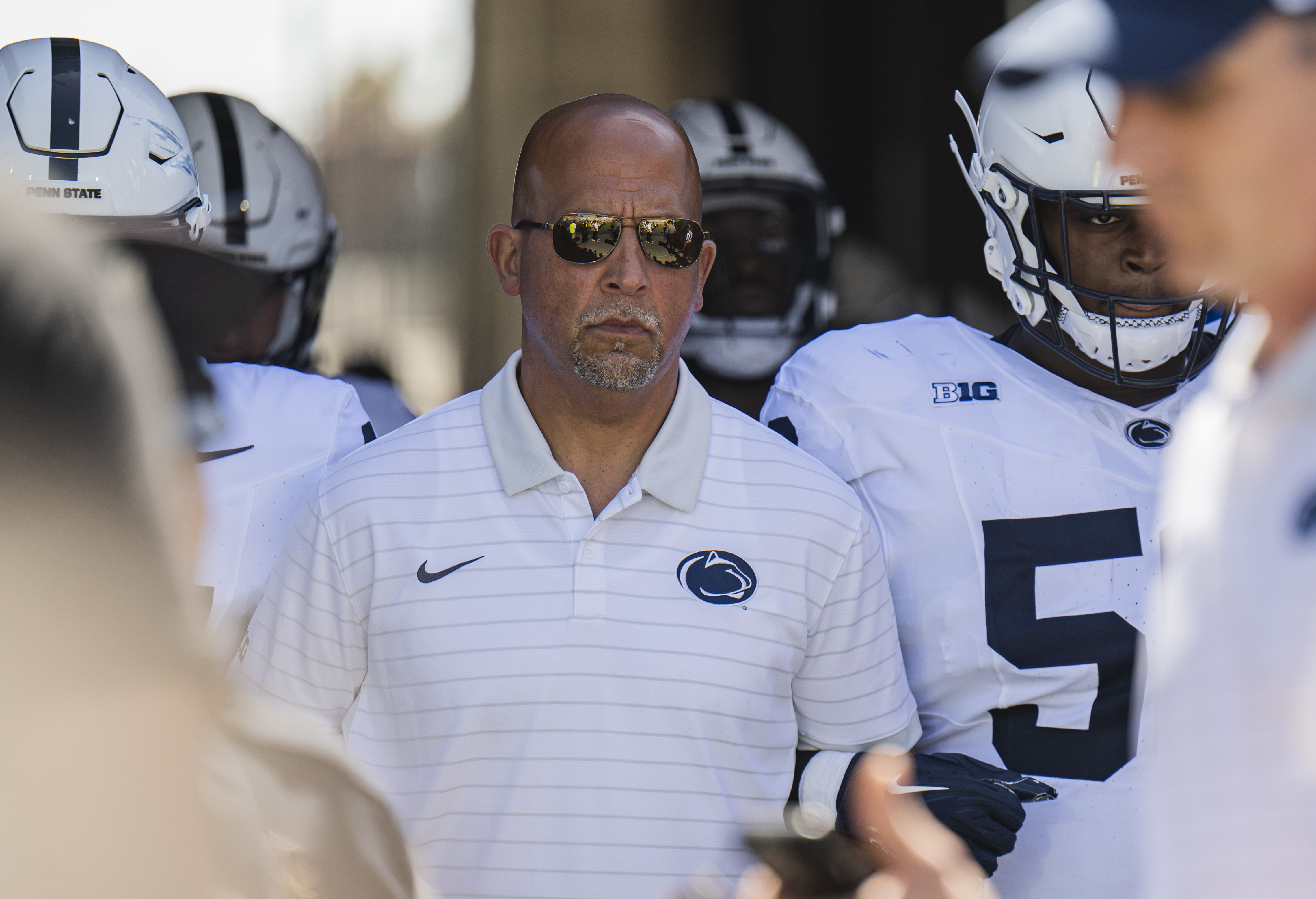 James Franklin, the former head coach of Penn State football, links arms and walks on the field with his players. (Daily Bruin file photo)