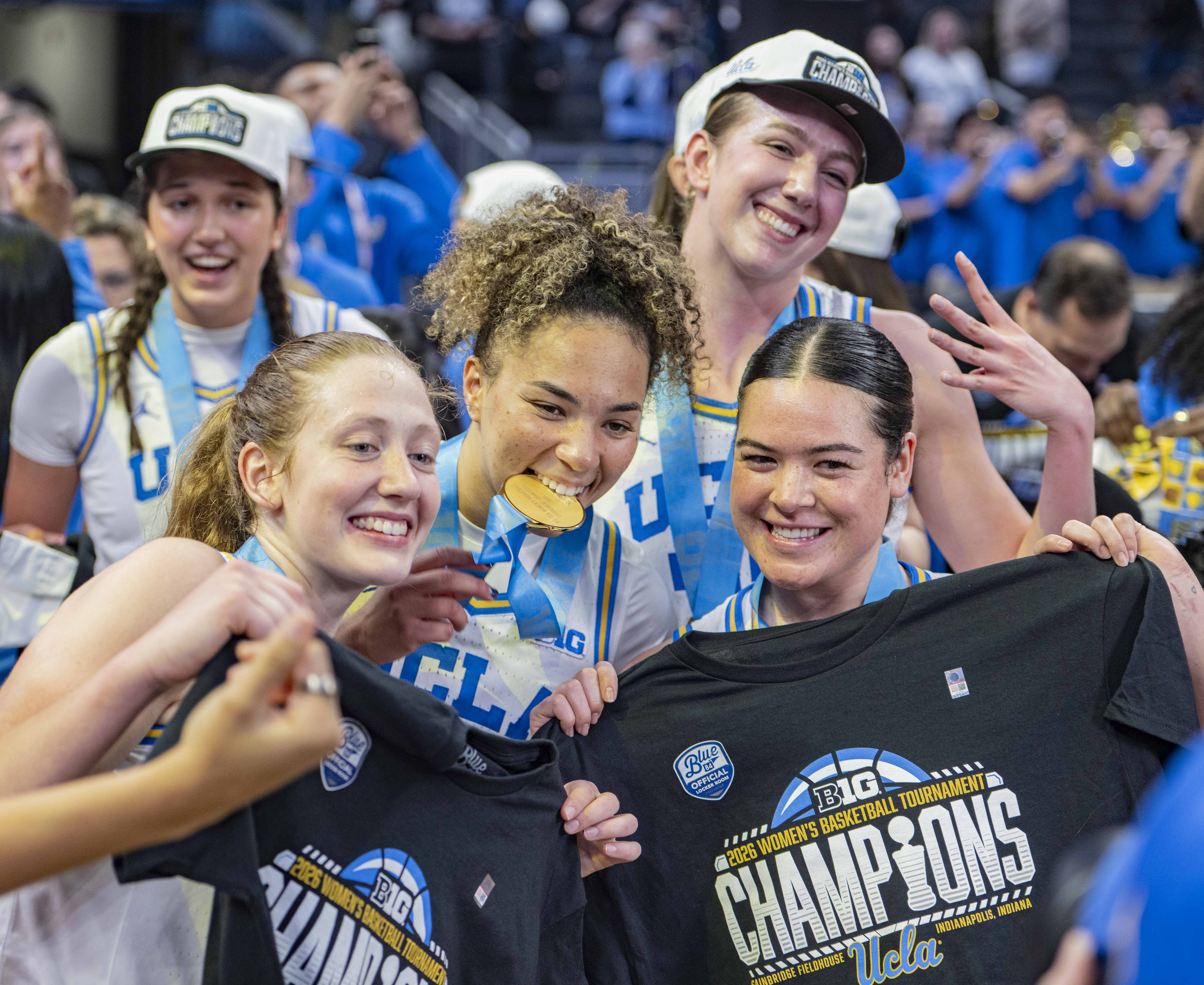 UCLA women's basketball players hold up championship T-shirts after defeating Iowa 96-45 in the title game. The Bruins went undefeated in the 2025-26 conference season. (Brianna Carlson/Daily Bruin staff)