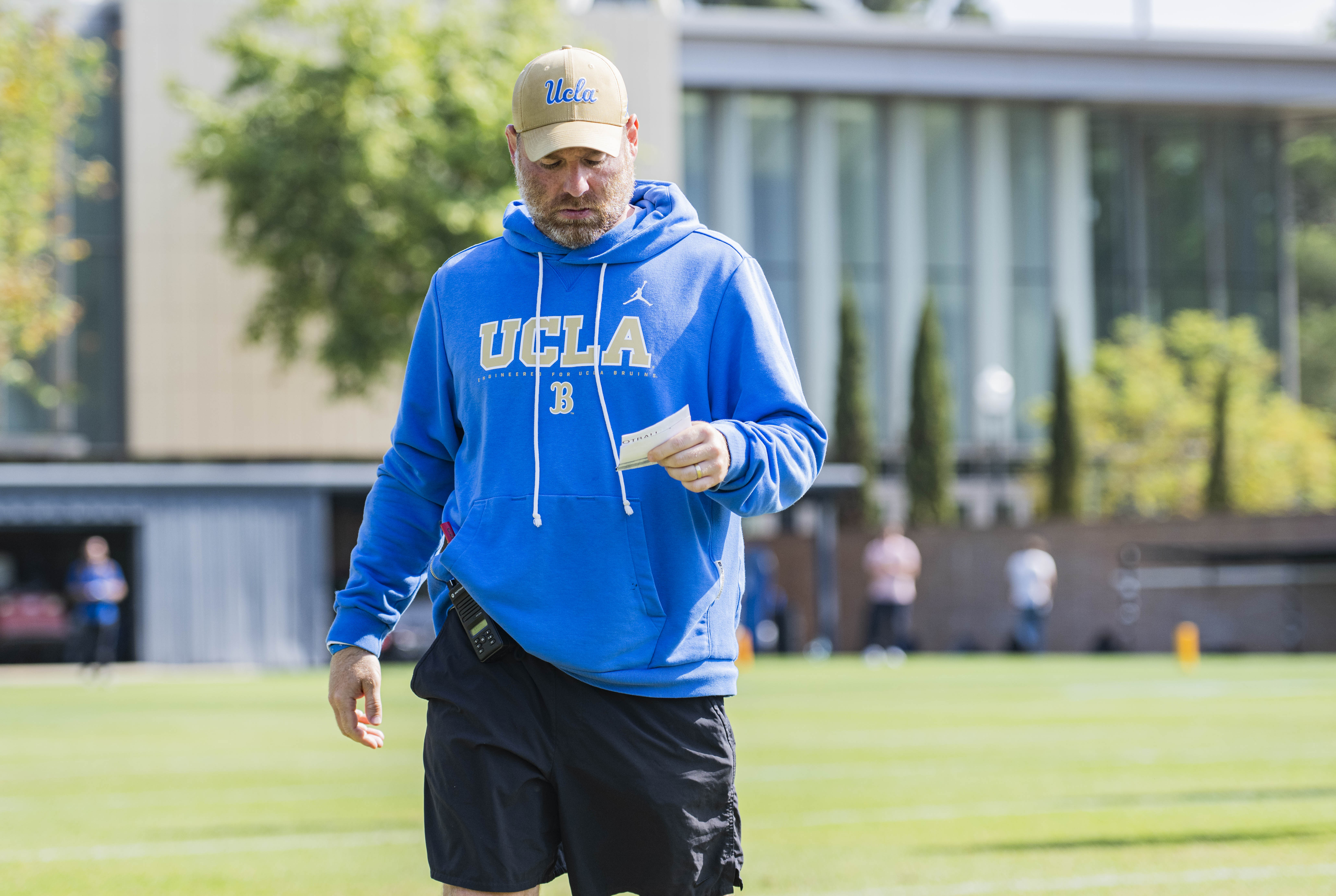 Defensive coordinator Colin Hitschler checks a piece of paper during practice at Spaulding Field on April 30. (Daily Bruin file photo)