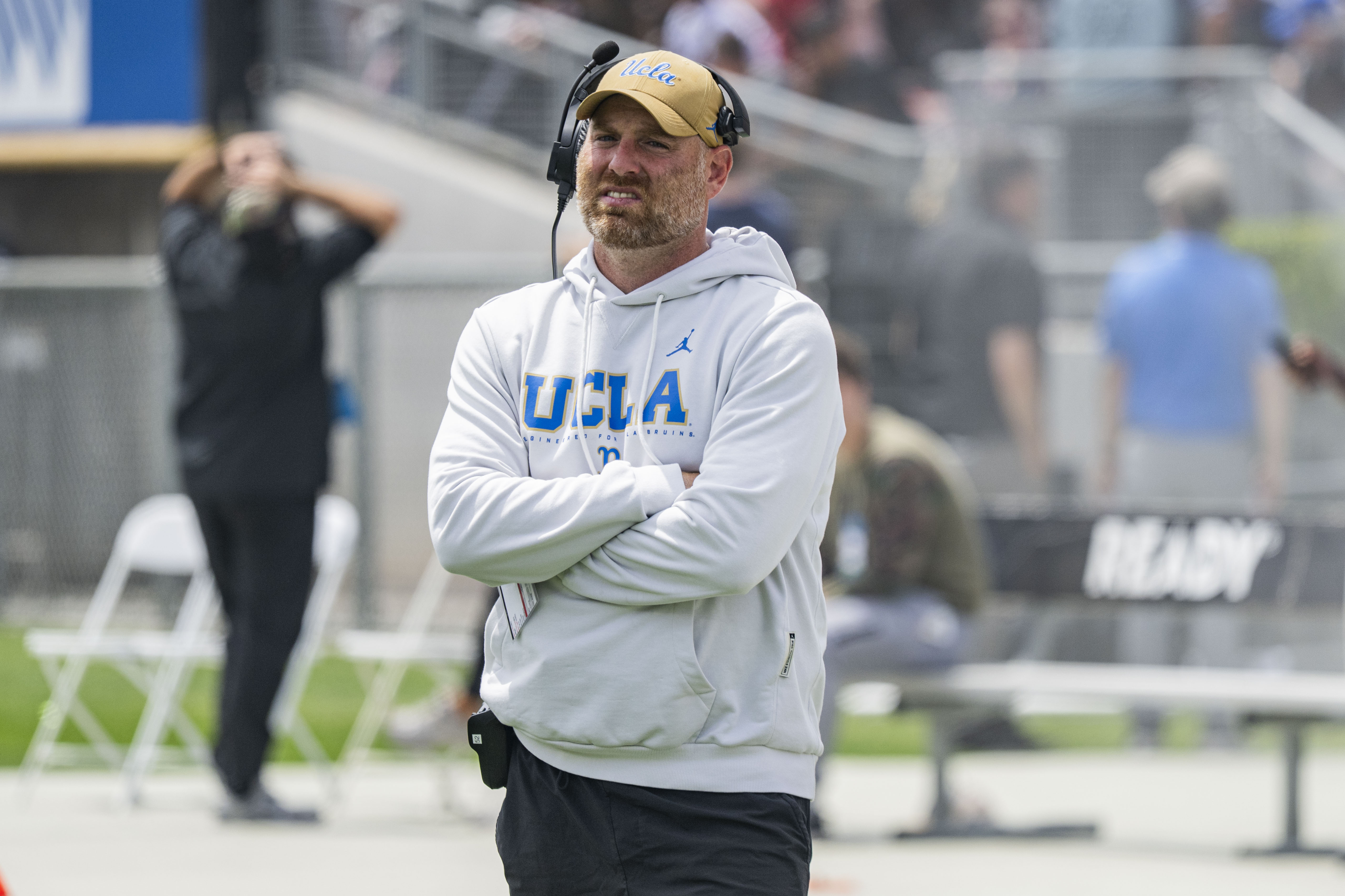 Defensive coordinator Colin Hitschler crosses his arms and looks toward the field during the Bruins' spring game May 2 at the Rose Bowl. (Kai Dizon/Assistant Photo editor)