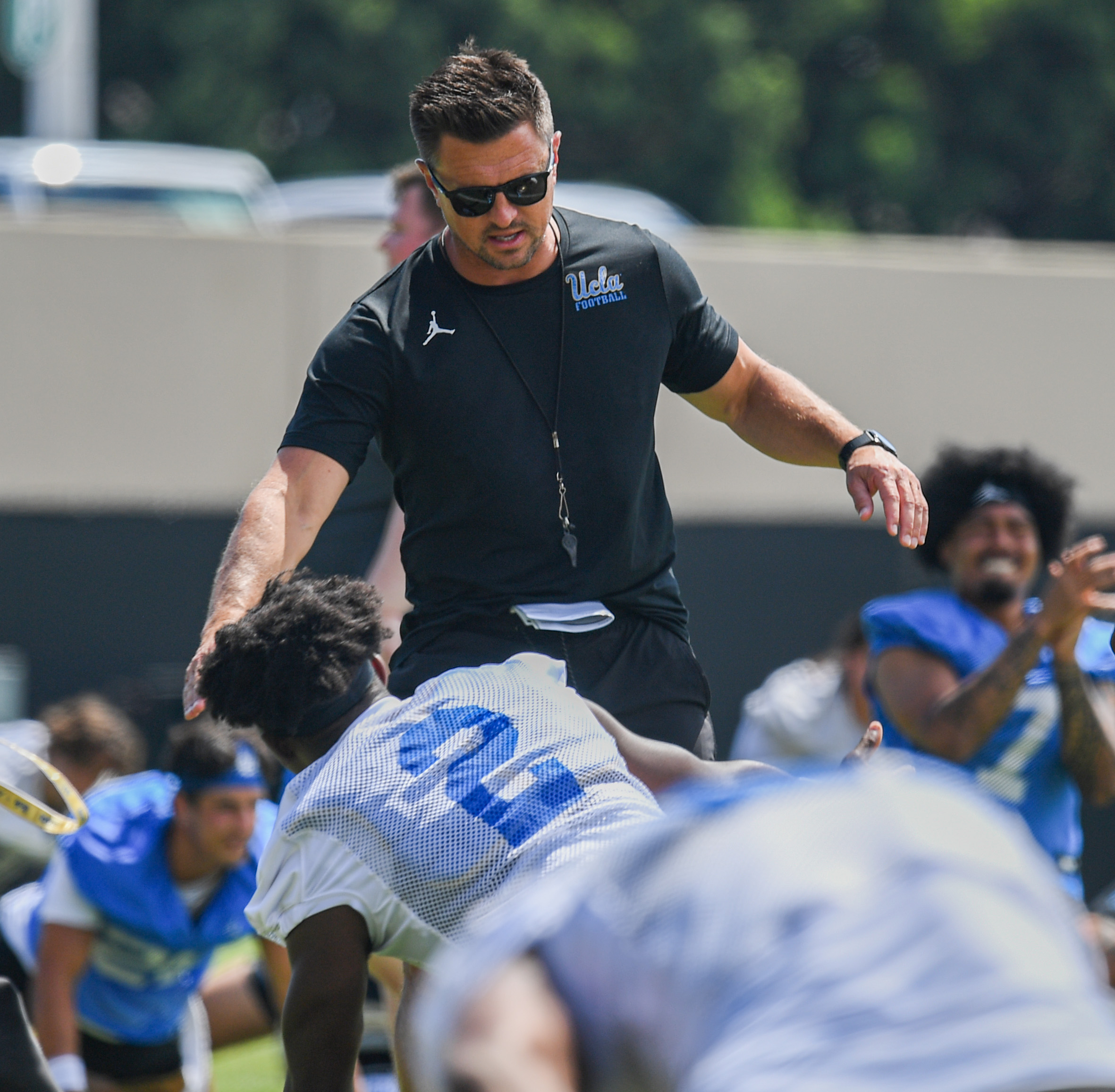 Coach Bob Chesney greets senior defensive back Rodrick Pleasant during the team’s stretching period on Friday, Aug. 7, 2026, at Spaulding Field. (Kai Dizon/Assistant Photo editor)