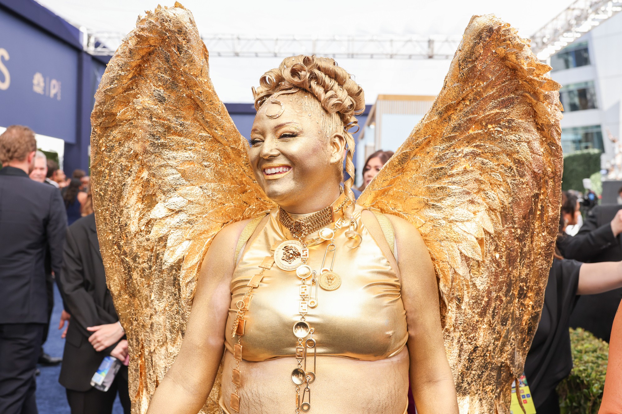 Megan Stalter smiles at the 78th Primetime Emmy Awards. The comedian and actress delivered a gold emsemble that featured matching wings and face paint. (Courtesy of Mark Von Holden/Invision for the Television Academy/AP Content Services)